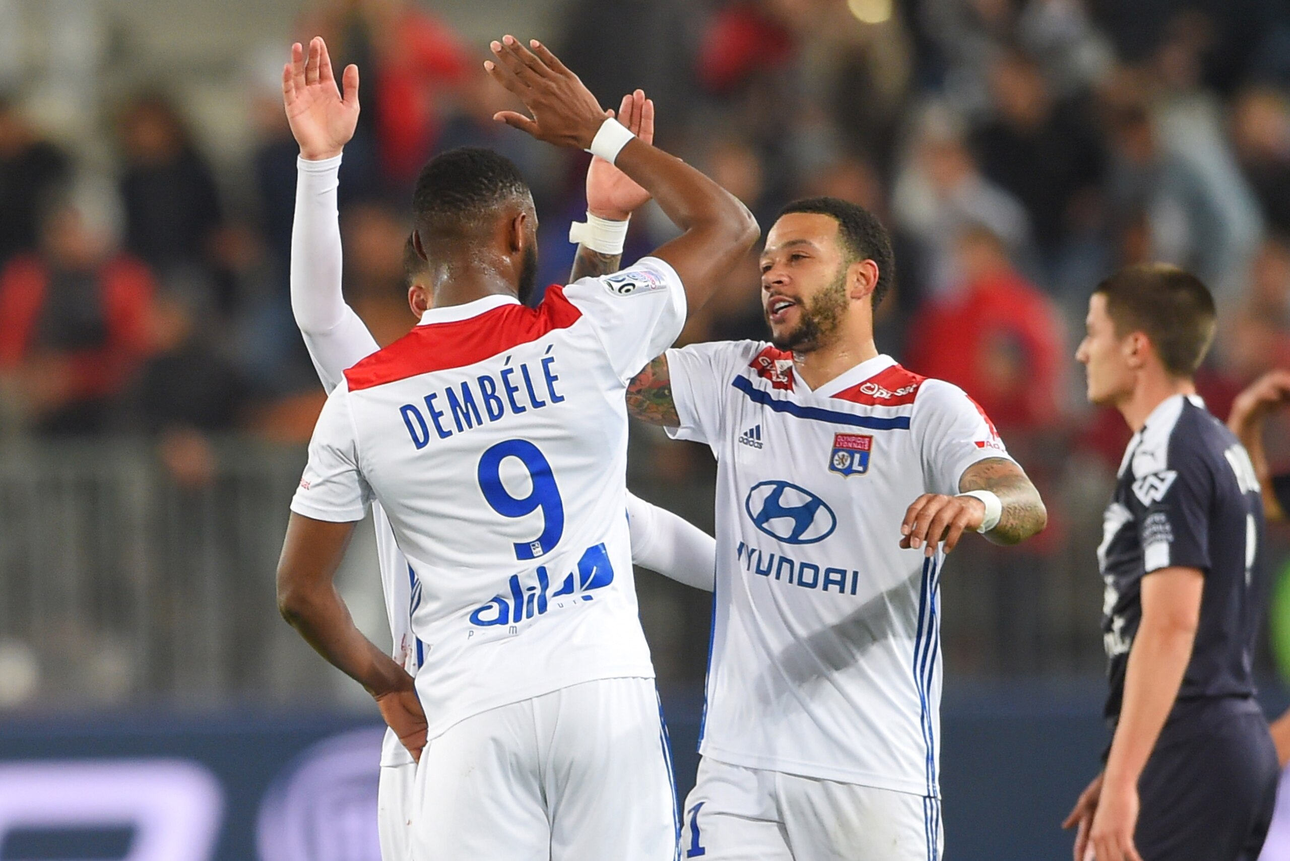 Lyon's French forward Moussa Dembele (L) and Lyon's Dutch forward Memphis Depay (C) celebrate at the end of the French L1 football match between Bordeaux (FCGB) and Lyon (OL) on April 26, 2019 at the Matmut Atlantique stadium in Bordeaux, southwestern Fra