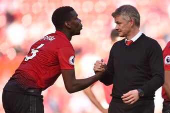 Manchester United's French midfielder Paul Pogba (L) shakes hands with Manchester United's Norwegian manager Ole Gunnar Solskjaer (R) on the pitch after  the English Premier League football match between Manchester United and Cardiff City at Old Trafford 