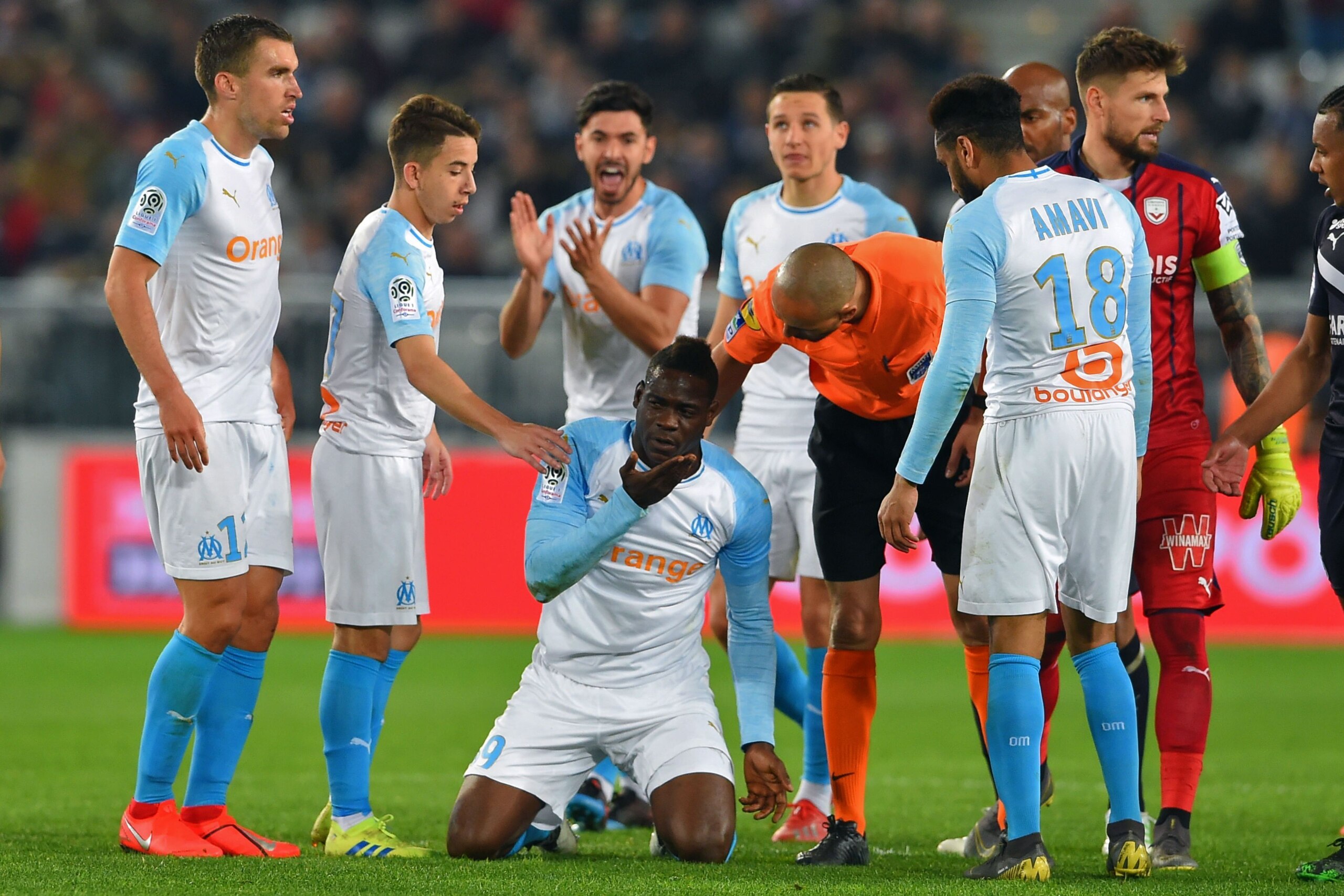 Marseille's Italian forward Mario Balotelli (C) reacts past French referee Hakim Ben El Hadj (C-R) during the French Ligue 1 football match between FC Girondins de Bordeaux and Olympique de Marseille at the Matmut Atlantique Stadium in Bordeaux, southwest
