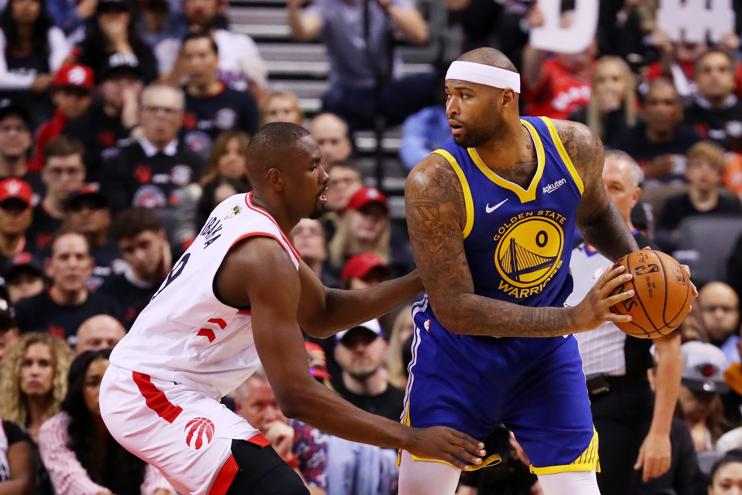 TORONTO, ONTARIO - MAY 30:  DeMarcus Cousins #0 of the Golden State Warriors is defended by Serge Ibaka #9 of the Toronto Raptors in the second half during Game One of the 2019 NBA Finals at Scotiabank Arena on May 30, 2019 in Toronto, Canada. NOTE TO USE