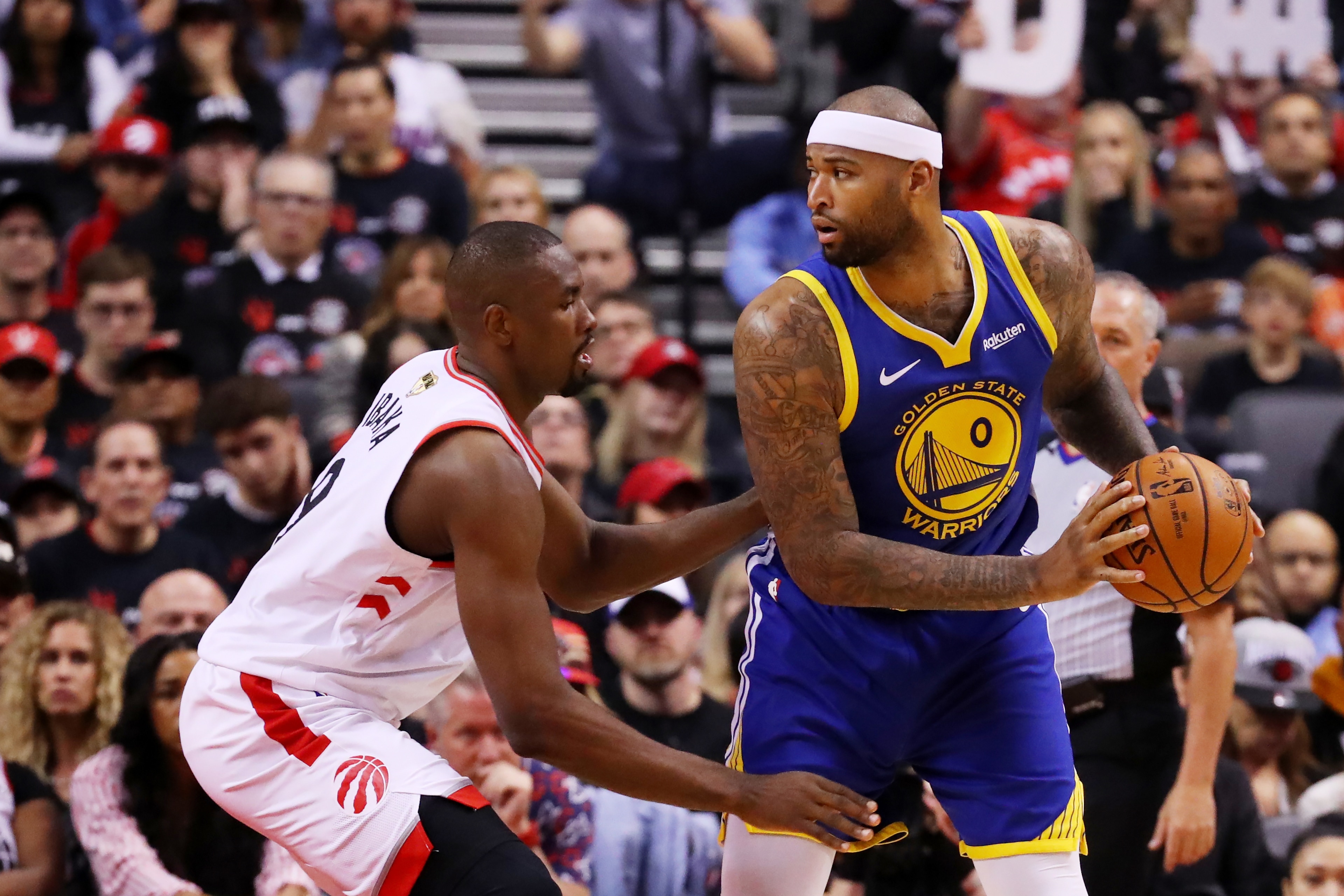 TORONTO, ONTARIO - MAY 30:  DeMarcus Cousins #0 of the Golden State Warriors is defended by Serge Ibaka #9 of the Toronto Raptors in the second half during Game One of the 2019 NBA Finals at Scotiabank Arena on May 30, 2019 in Toronto, Canada. NOTE TO USE
