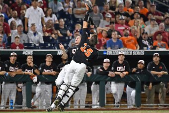 Omaha, NE - JUNE 26:  Infielder Michael Gretler #10 of the Oregon State Beavers and catcher Adley Rutschman #35 collide attempting to catch a foul ball in the ninth inning against the Arkansas Razorbacks during game one of the College World Series Champio