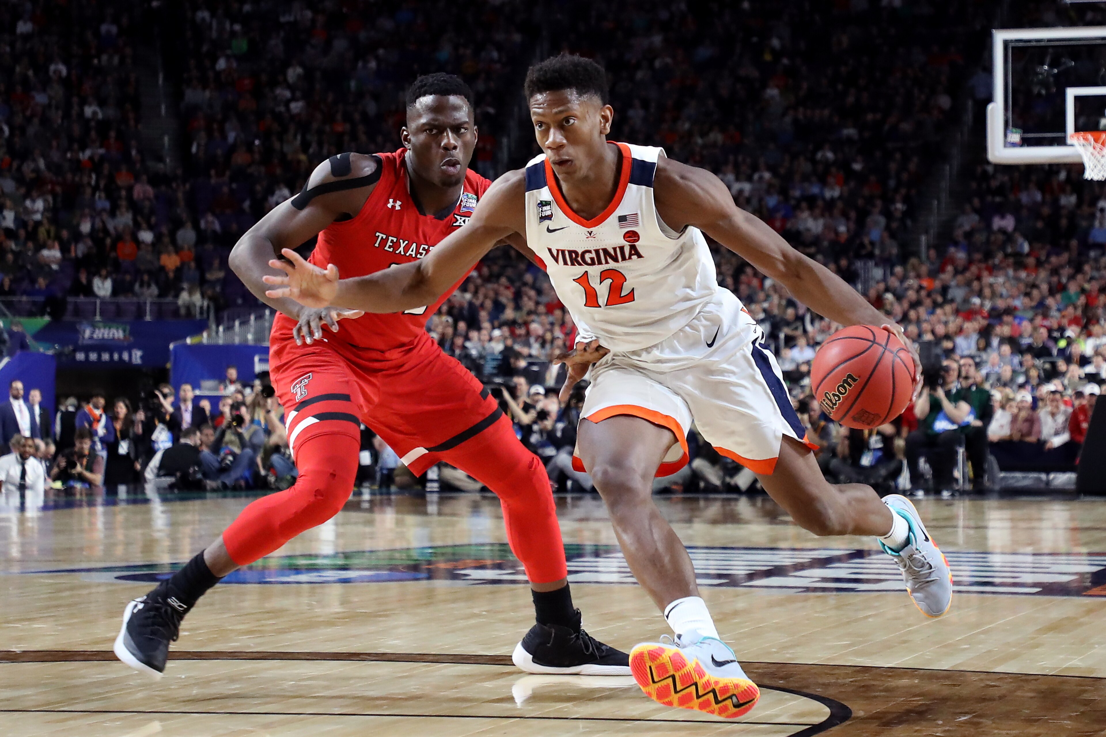 MINNEAPOLIS, MINNESOTA - APRIL 08: De'Andre Hunter #12 of the Virginia Cavaliers is defended by Norense Odiase #32 of the Texas Tech Red Raiders in the second half during the 2019 NCAA men's Final Four National Championship game at U.S. Bank Stadium on A MINNEAPOLIS, MINNESOTA - APRIL 08: De'Andre Hunter #12 of the Virginia Cavaliers is defended by Norense Odiase #32 of the Texas Tech Red Raiders in the second half during the 2019 NCAA men's Final Four National Championship game at U.S. Bank Stadium on A