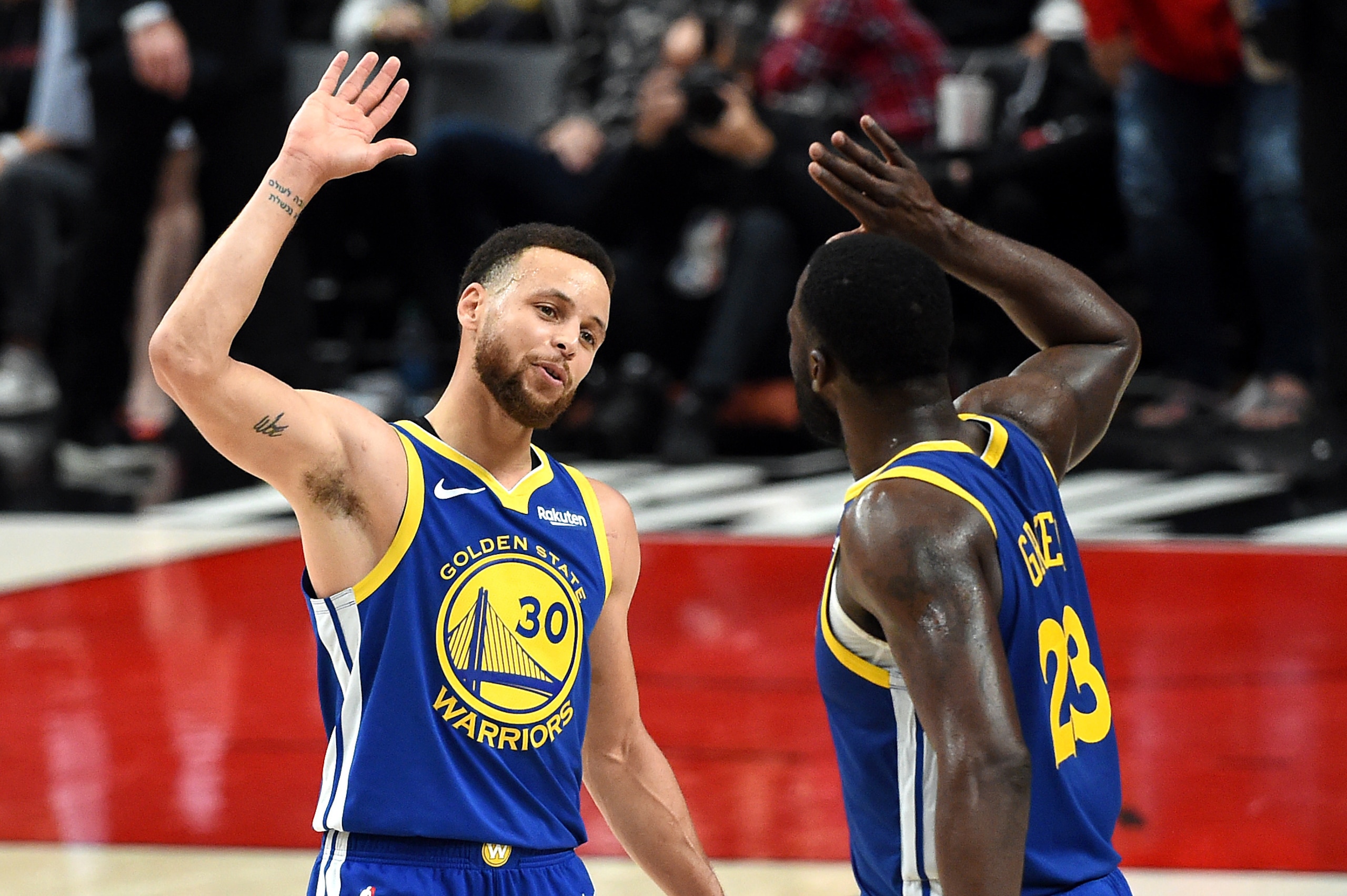 PORTLAND, OREGON - MAY 18: Stephen Curry #30 of the Golden State Warriors celebrates with Draymond Green #23 during the second half against the Portland Trail Blazers in game three of the NBA Western Conference Finals at Moda Center on May 18, 2019 in Por
