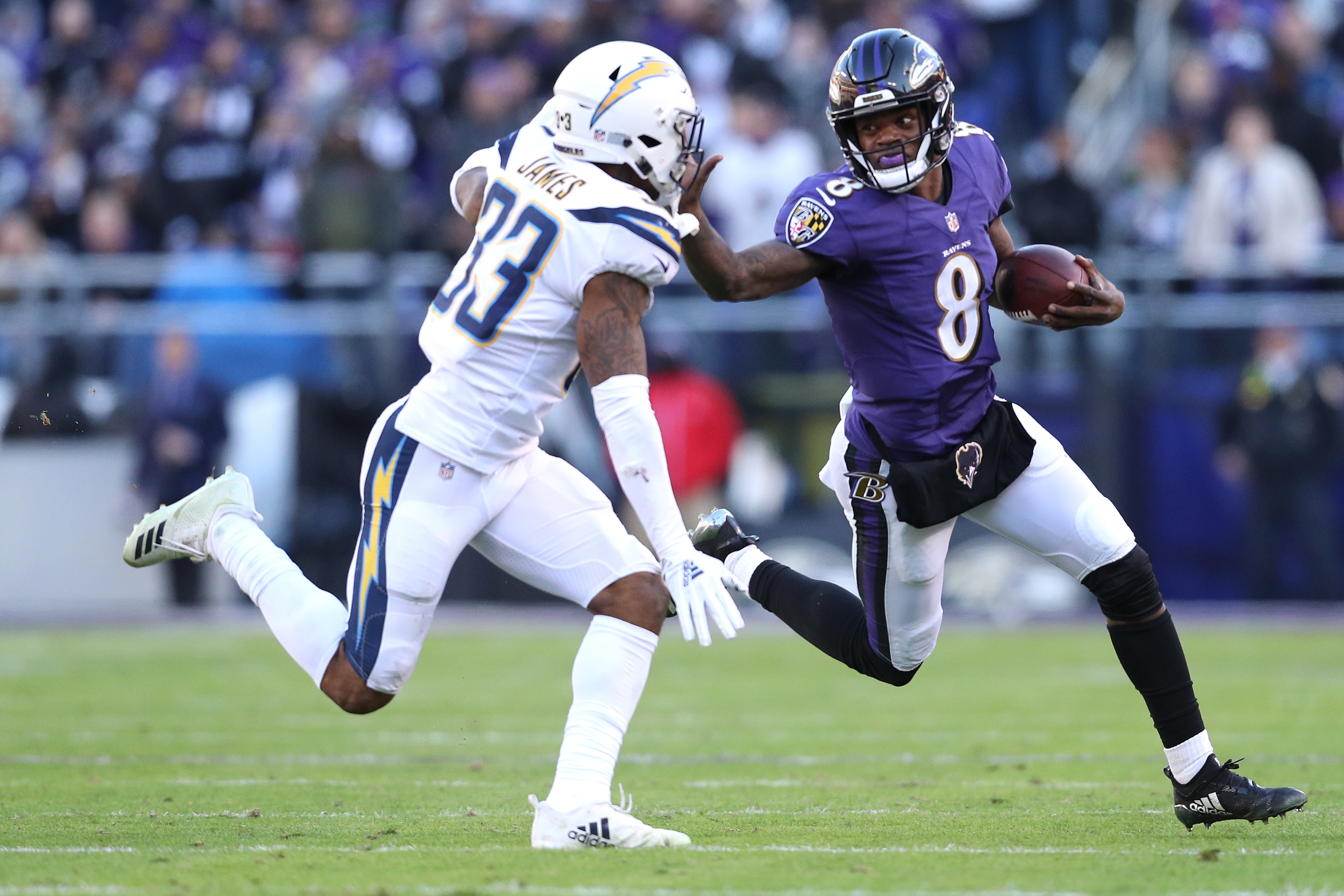 BALTIMORE, MARYLAND - JANUARY 06: Quarterback Lamar Jackson #8 of the Baltimore Ravens stiff arms free safety Derwin James #33 of the Los Angeles Chargers in the second half during the AFC Wild Card Playoff game at M&T Bank Stadium on January 06, 2019 in BALTIMORE, MARYLAND - JANUARY 06: Quarterback Lamar Jackson #8 of the Baltimore Ravens stiff arms free safety Derwin James #33 of the Los Angeles Chargers in the second half during the AFC Wild Card Playoff game at M&T Bank Stadium on January 06, 2019 in