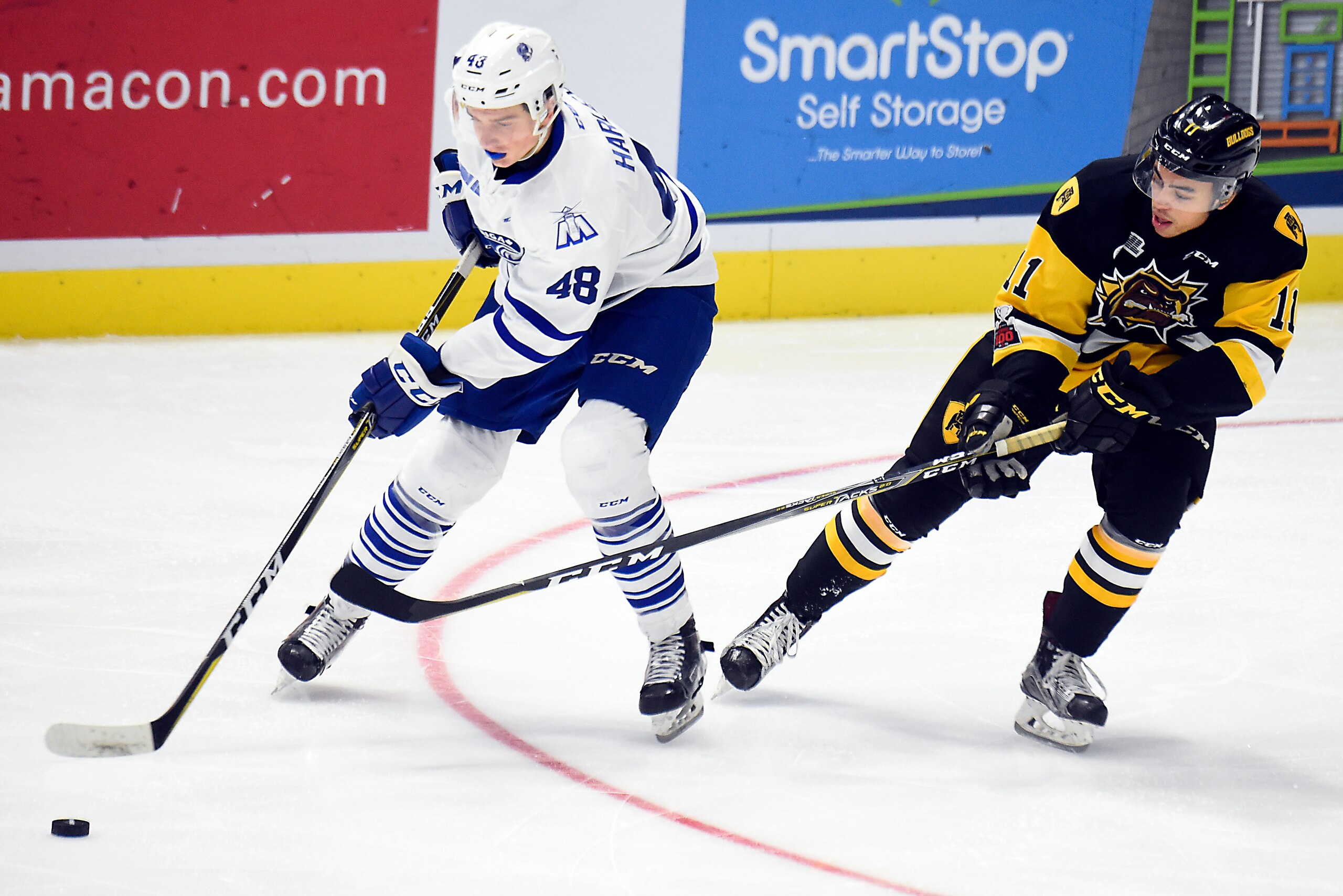 MISSISSAUGA, ON - DECEMBER 10: Thomas Harley #48 of the Mississauga Steelheads controls the puck against Isaac Nurse #11 of the Hamilton Bulldogs during game action on December 10, 2017 at Hershey Centre in Mississauga, Ontario, Canada. (Photo by Graig Ab