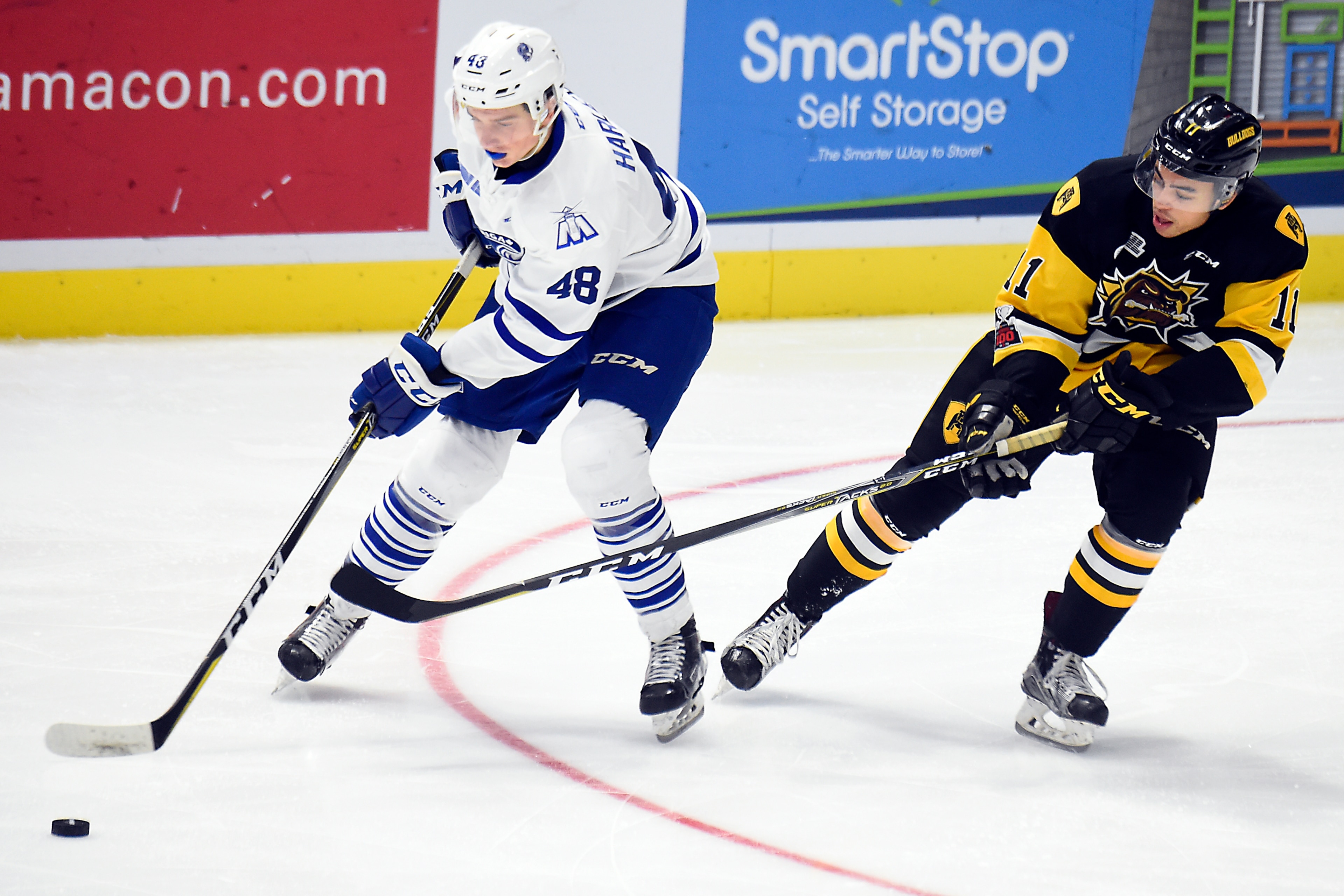 MISSISSAUGA, ON - DECEMBER 10: Thomas Harley #48 of the Mississauga Steelheads controls the puck against Isaac Nurse #11 of the Hamilton Bulldogs during game action on December 10, 2017 at Hershey Centre in Mississauga, Ontario, Canada. (Photo by Graig Ab