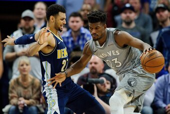 MINNEAPOLIS, MN - APRIL 11: Jimmy Butler #23 of the Minnesota Timberwolves drives to the basket against Jamal Murray #27 of the Denver Nuggets during overtime of the game on April 11, 2018 at the Target Center in Minneapolis, Minnesota. The Timberwolves d