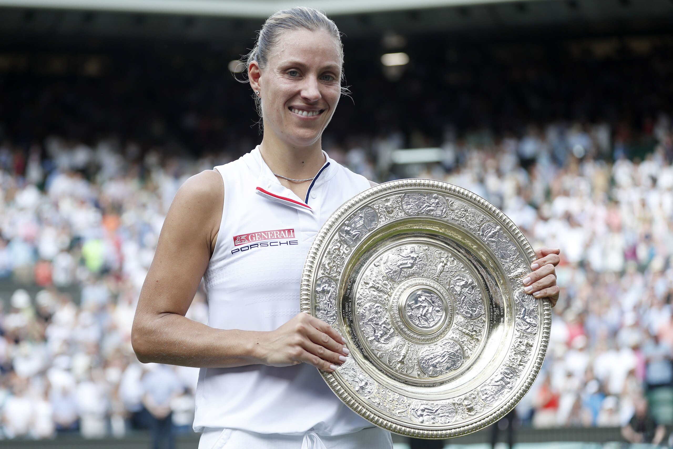 Germany's Angelique Kerber poses with the winner's trophy, the Venus Rosewater Dish, after her women's singles final victory over US player Serena Williams on the twelfth day of the 2018 Wimbledon Championships at The All England Lawn Tennis Club in Wimbl