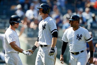 NEW YORK, NEW YORK - JUNE 23:   DJ LeMahieu #26 (C) of the New York Yankees celebrates his fifth inning three run home run against the Houston Astros with teammates Brett Gardner #11 (L) and Aaron Hicks #31 at Yankee Stadium on June 23, 2019 in New York C