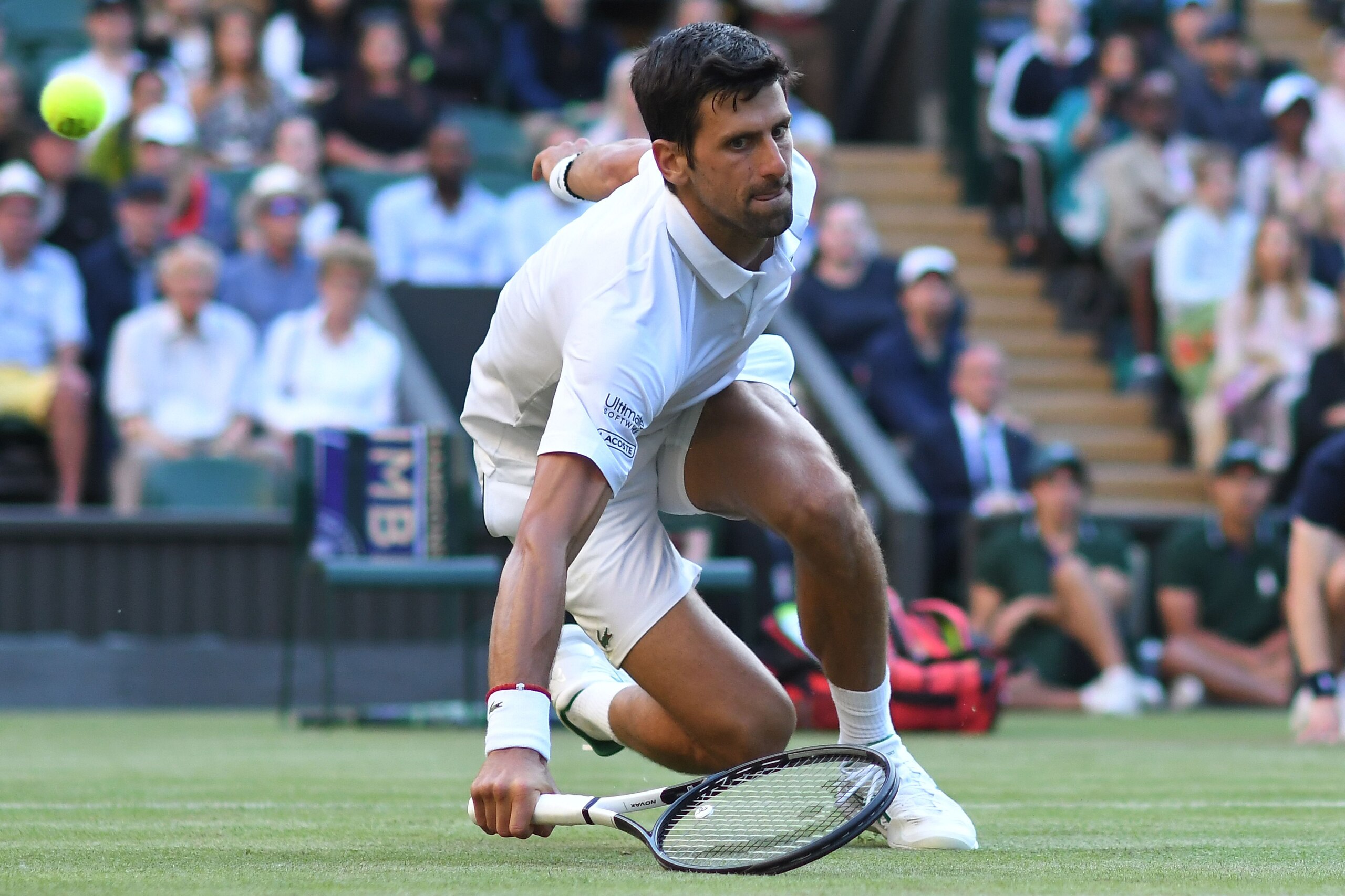 Serbia's Novak Djokovic slips over reaching for a return against US player Denis Kudla during their men's singles second round match on the third day of the 2019 Wimbledon Championships at The All England Lawn Tennis Club in Wimbledon, southwest London, o Serbia's Novak Djokovic slips over reaching for a return against US player Denis Kudla during their men's singles second round match on the third day of the 2019 Wimbledon Championships at The All England Lawn Tennis Club in Wimbledon, southwest London, o