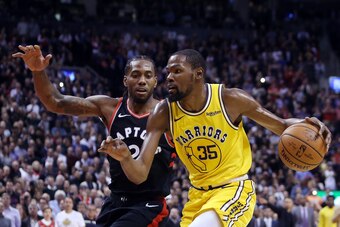 TORONTO, ON - NOVEMBER 29:  Kevin Durant #35 of the Golden State Warriors dribbles the ball as Kawhi Leonard #2 of the Toronto Raptors defends during the second half of an NBA game at Scotiabank Arena on November 29, 2018 in Toronto, Canada.  NOTE TO USER