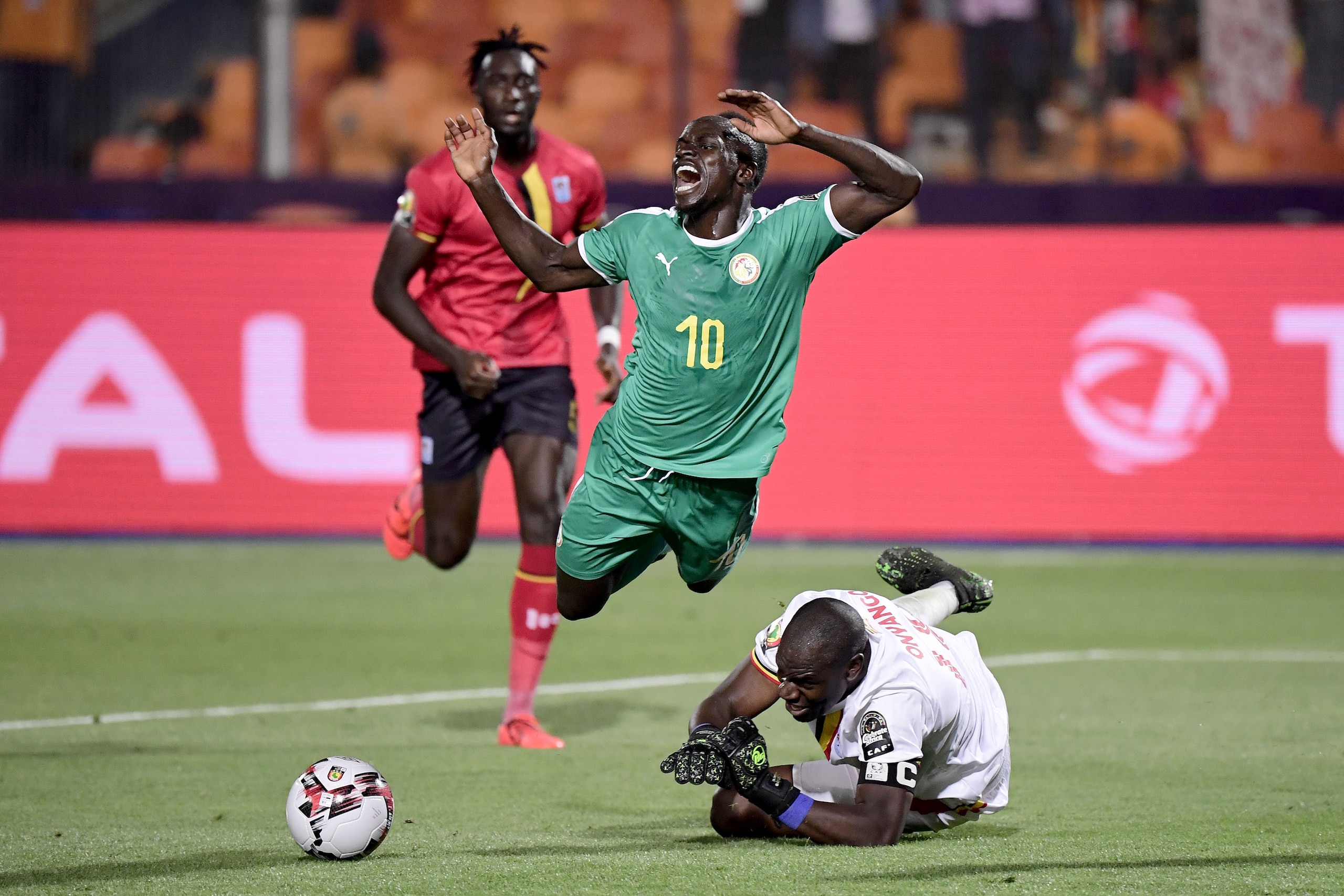 Uganda's goalkeeper Denis Onyango (below) fouls Senegal's forward Sadio Mane (C) during the 2019 Africa Cup of Nations (CAN) Round of 16 football match between Uganda and Senegal at the Cairo International Stadium in the Egyptian capital on July 5, 2019. 