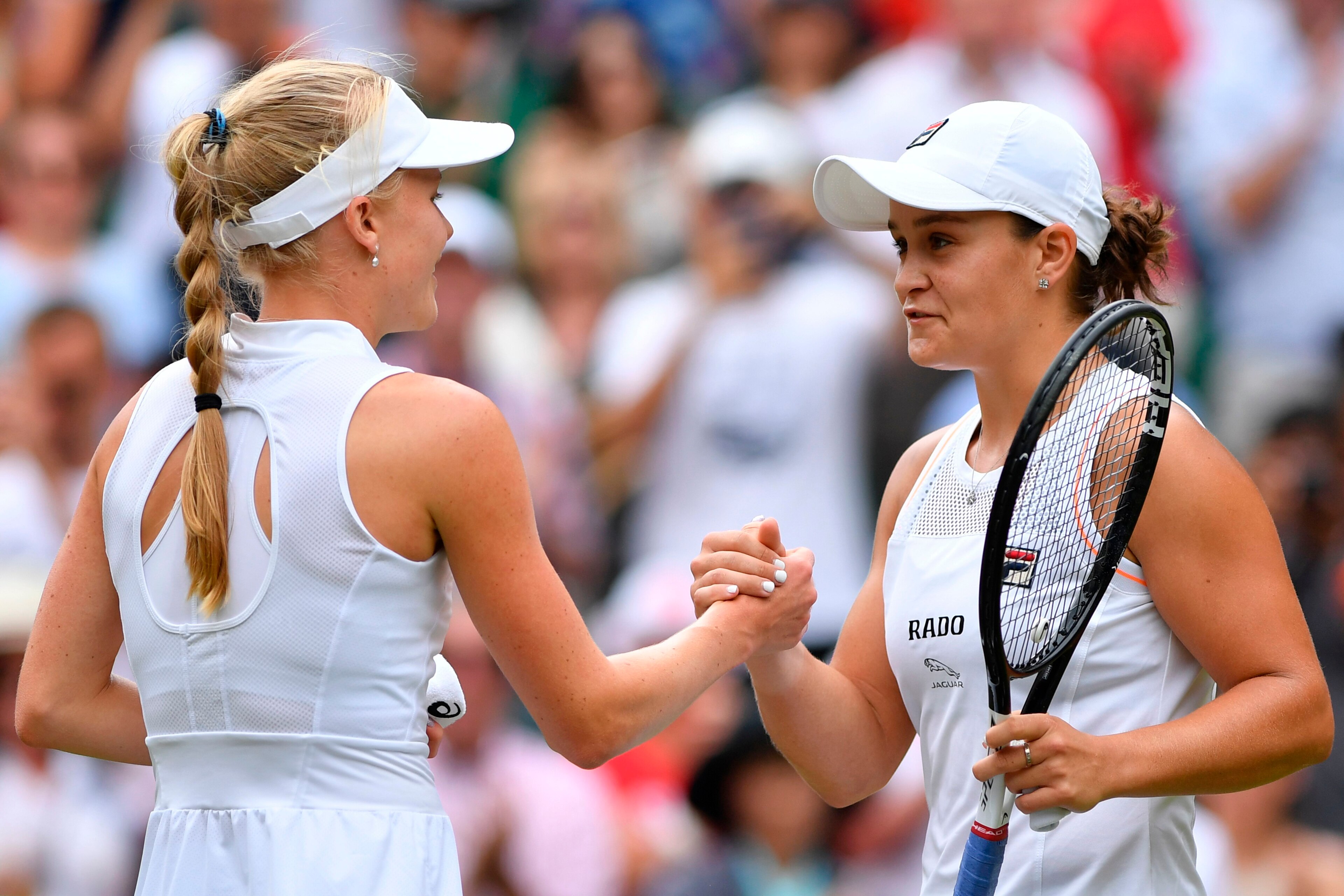 Australia's Ashleigh Barty (R) shakes hands with Britain's Harriet Dart (L) after Barty won their women's singles third round match on the sixth day of the 2019 Wimbledon Championships at The All England Lawn Tennis Club in Wimbledon, southwest London, on