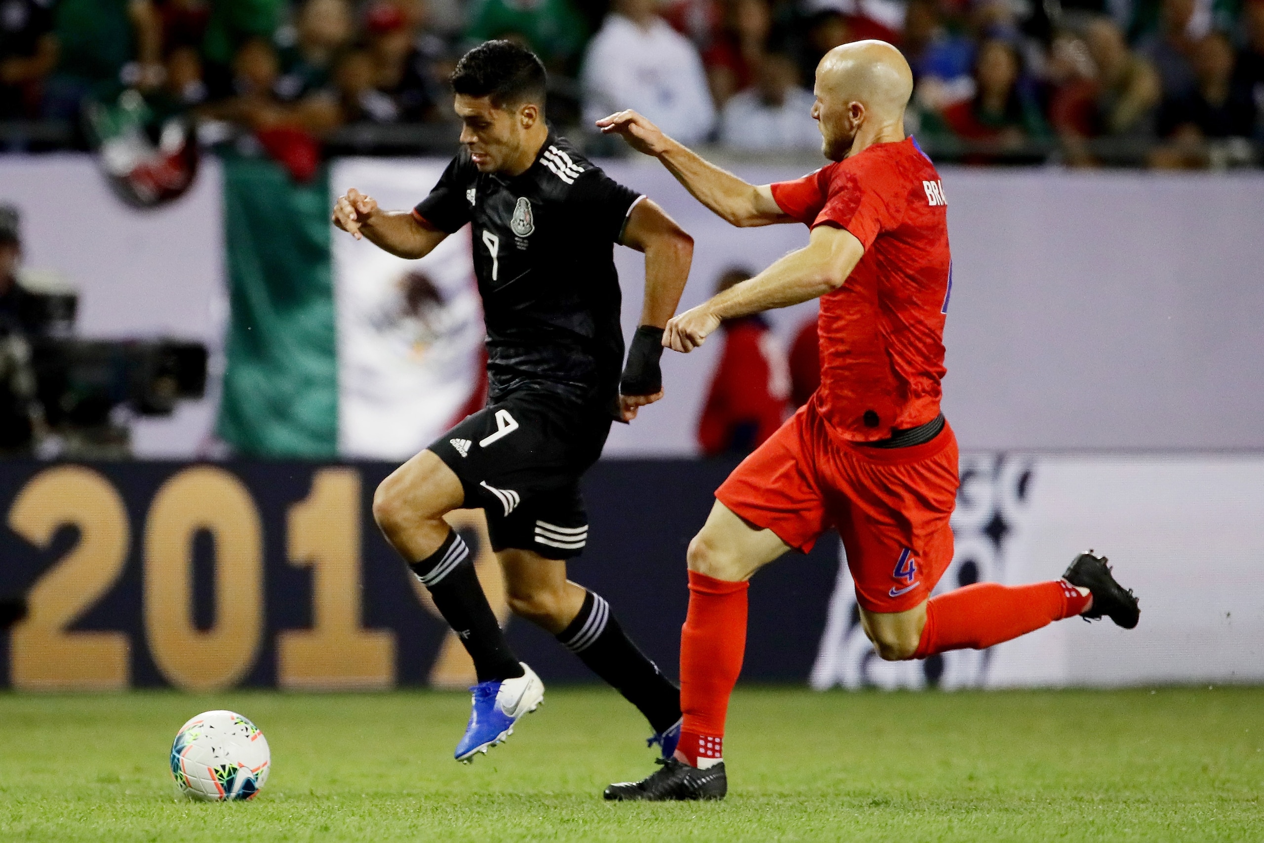 CHICAGO, ILLINOIS - JULY 07:  Raul Jimenez #9 of the Mexico dribbles the ball while being defended by Michael Bradley #4 of the United States in the second half during the 2019 CONCACAF Gold Cup Final at Soldier Field on July 07, 2019 in Chicago, Illinois