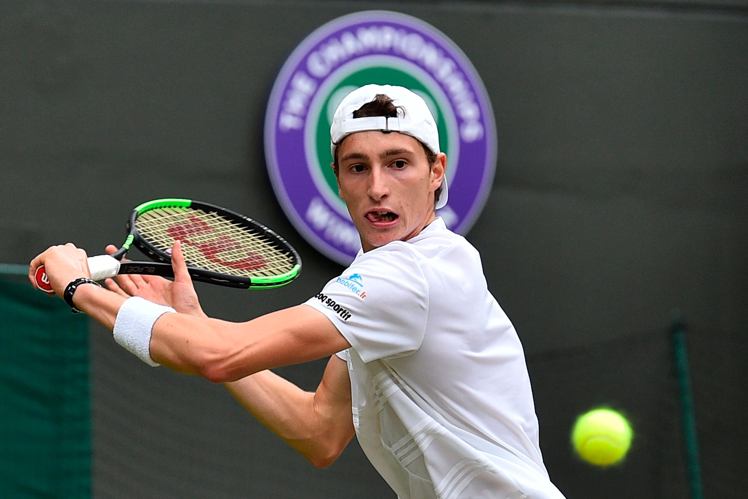 France's Ugo Humbert returns against Serbia's Novak Djokovic uring their men's singles fourth round match on the seventh day of the 2019 Wimbledon Championships at The All England Lawn Tennis Club in Wimbledon, southwest London, on July 8, 2019. (Photo by