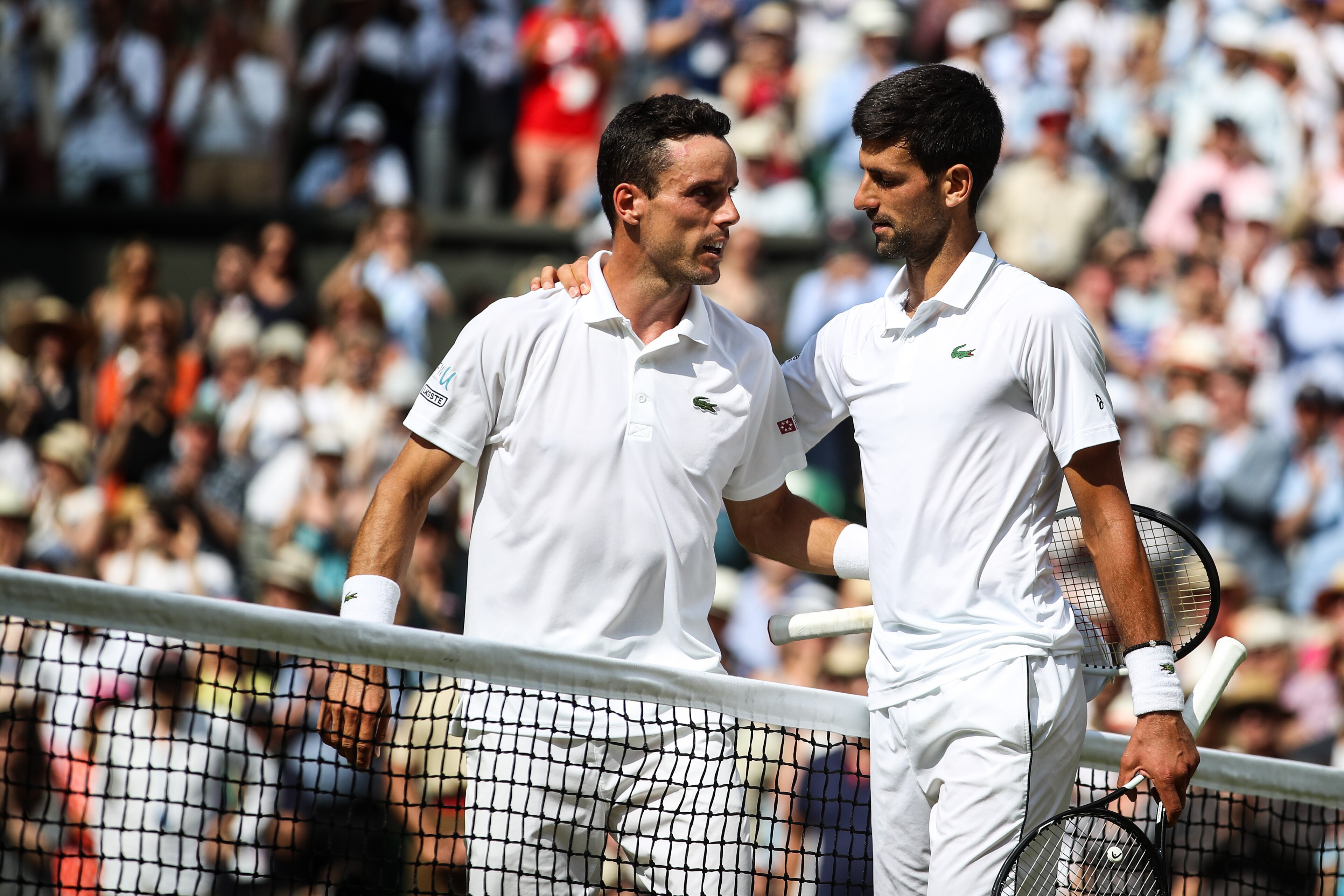 LONDON, ENGLAND - JULY 12: Novak Djokovic(R) of Serbia greets Roberto Bautista Agut of Spain after their Men's Singles semi-final match during Day eleven of The Championships - Wimbledon 2019 at All England Lawn Tennis and Croquet Club on July 12, 2019 in