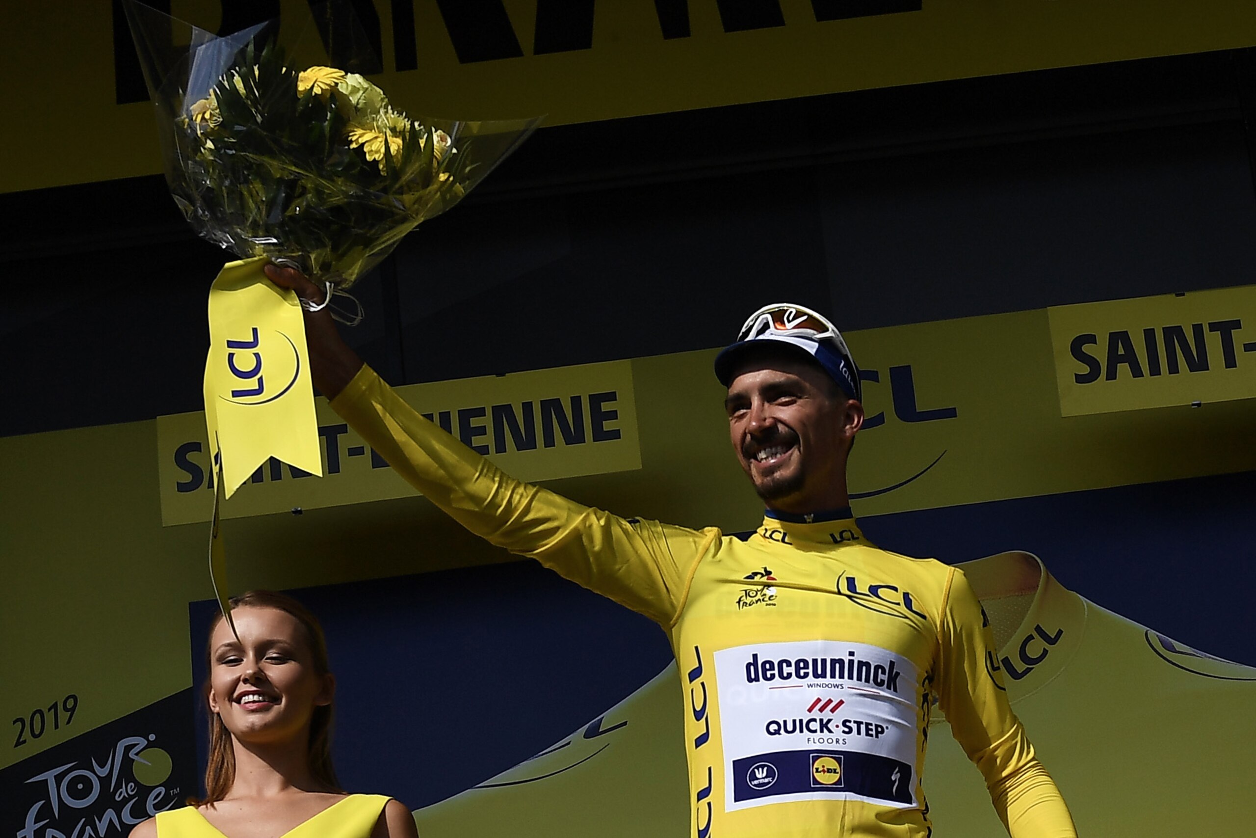 France's Julian Alaphilippe (R) celebrates his overall leader's yellow jersey on the podium of the eighth stage of the 106th edition of the Tour de France cycling race between Macon and Saint-Etienne, in Saint-Etienne, eastern France, on July 13, 2019. (P