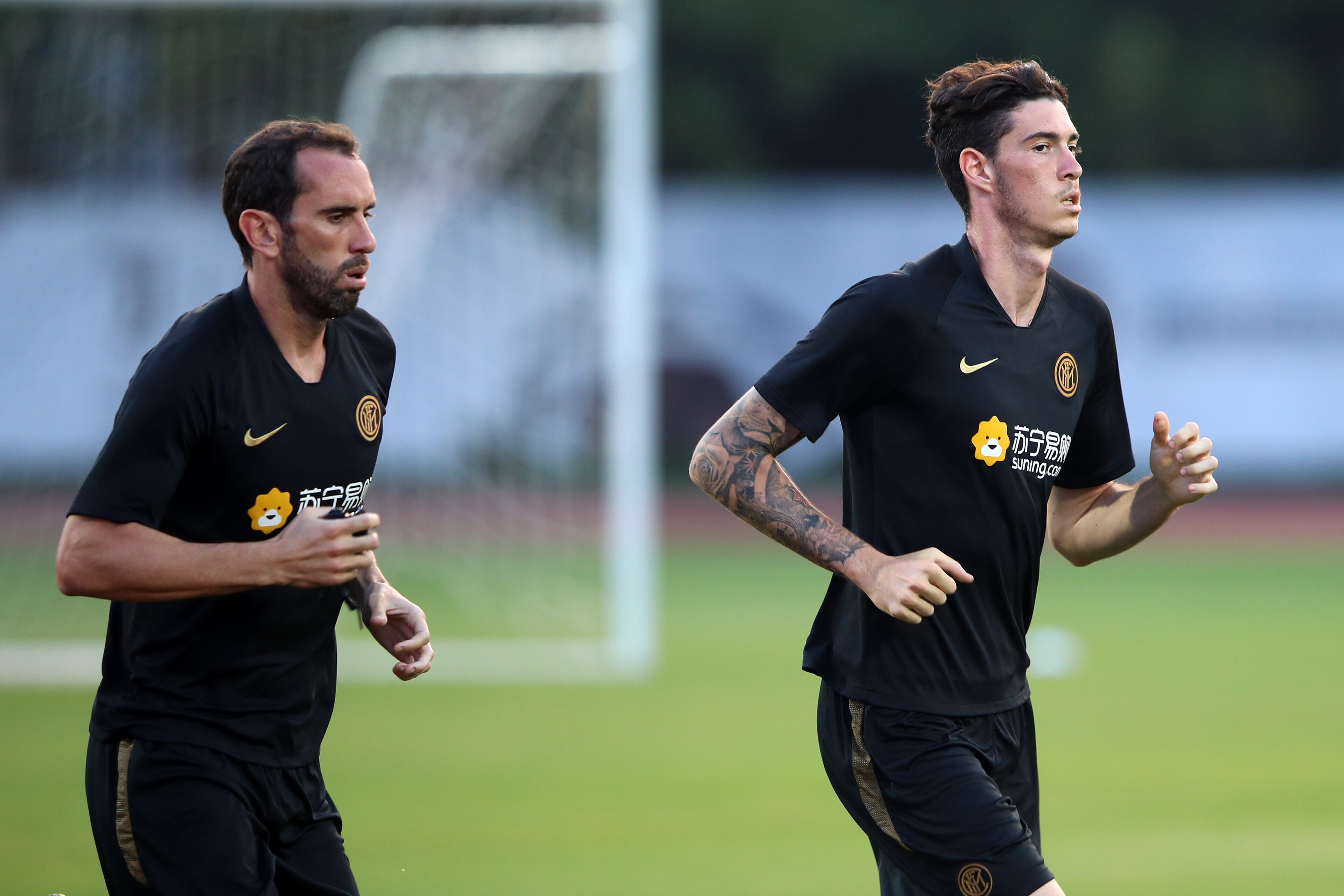 NANJING, CHINA - JULY 23: Diego Godin (L) and Alessandro Bastoni (R) of FC Internazionale warm up during the FC Internazionale official Training at the Nanjing Olympic Center Stadium on July 23, 2019 in Nanjing, China. (Photo by Lintao Zhang/International