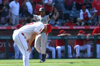 ANAHEIM, CA - APRIL 21: Mallex Smith #0 of the Seattle Mariners celebrates at third bas as relief pitcher Cody Allen #37 of the Los Angeles Angels of Anaheim hangs his head after giving up a two run home run to Mitch Haniger #17 of the Seattle Mariners in