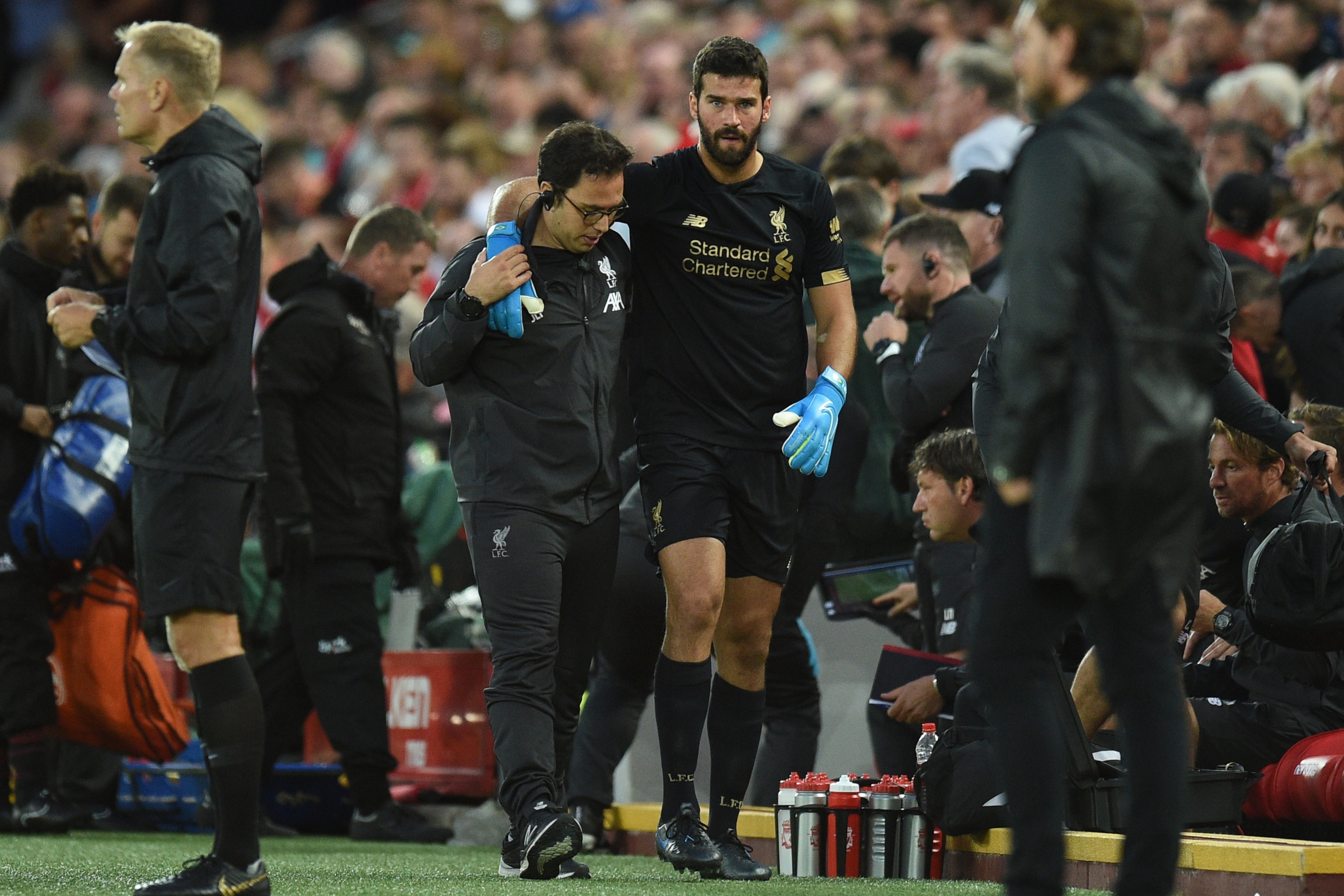 Liverpool's Brazilian goalkeeper Alisson Becker (CR) is assisted off the field with an injury during the English Premier League football match between Liverpool and Norwich City at Anfield in Liverpool, north west England on August 9, 2019. (Photo by Oli Liverpool's Brazilian goalkeeper Alisson Becker (CR) is assisted off the field with an injury during the English Premier League football match between Liverpool and Norwich City at Anfield in Liverpool, north west England on August 9, 2019. (Photo by Oli