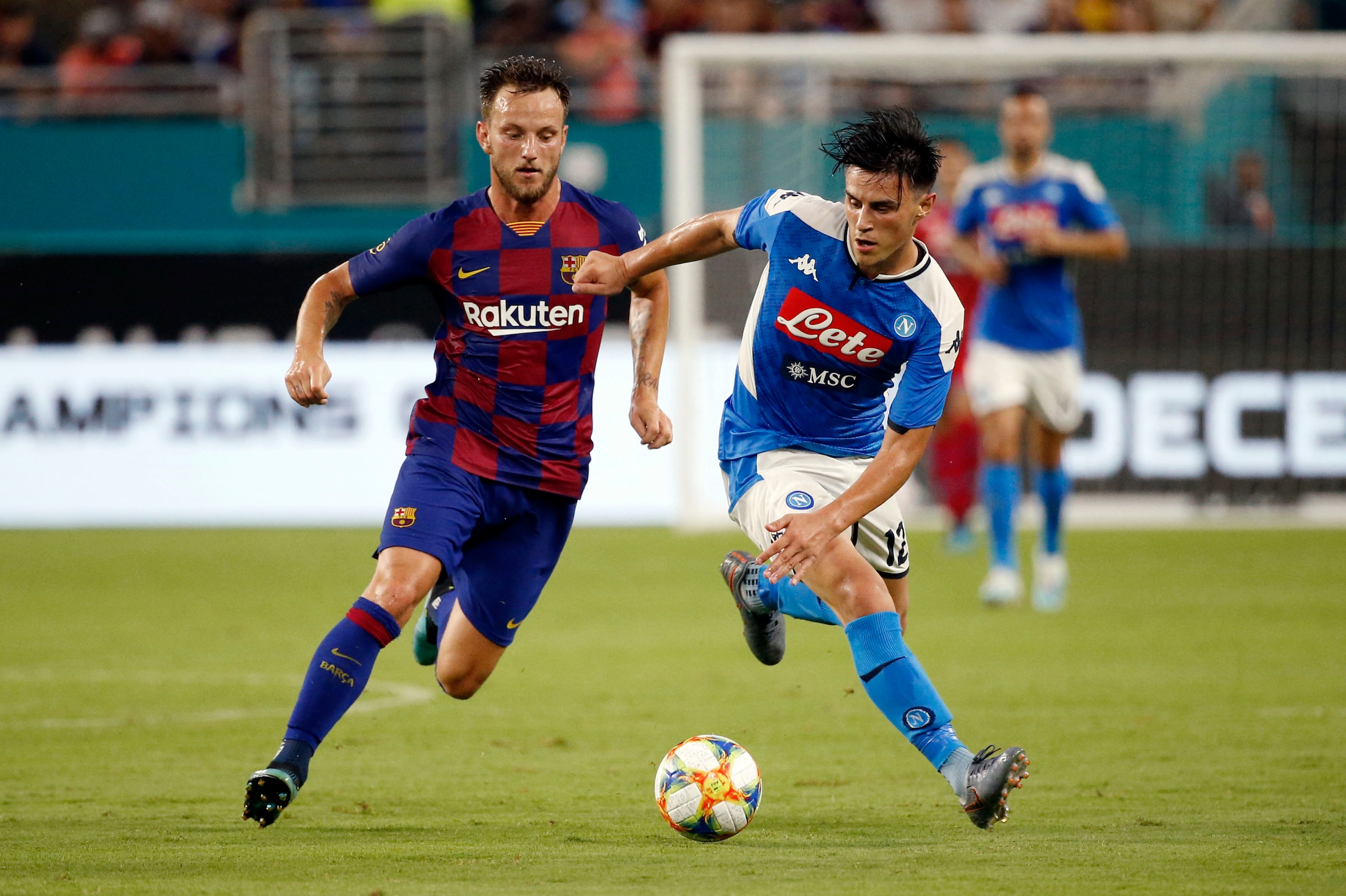 Napoli's Lorenzo Insigne (R) battles for the ball with Barcelona's Ivan Rakitic during the International Champions Cup football match between FC Barcelona and SSC Napoli at Hard Rock Stadium in Miami, Florida, on August 7, 2019. (Photo by RHONA WISE / AFP