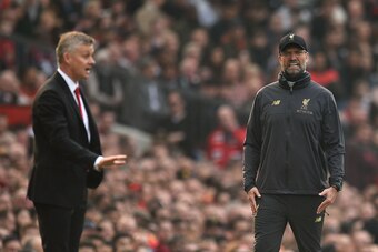 Liverpool's German manager Jurgen Klopp (R) and Manchester United's  Norwegian caretaker manager Ole Gunnar Solskjaer (L) gesture to their players during the English Premier League football match between Manchester United and Liverpool at Old Trafford in 