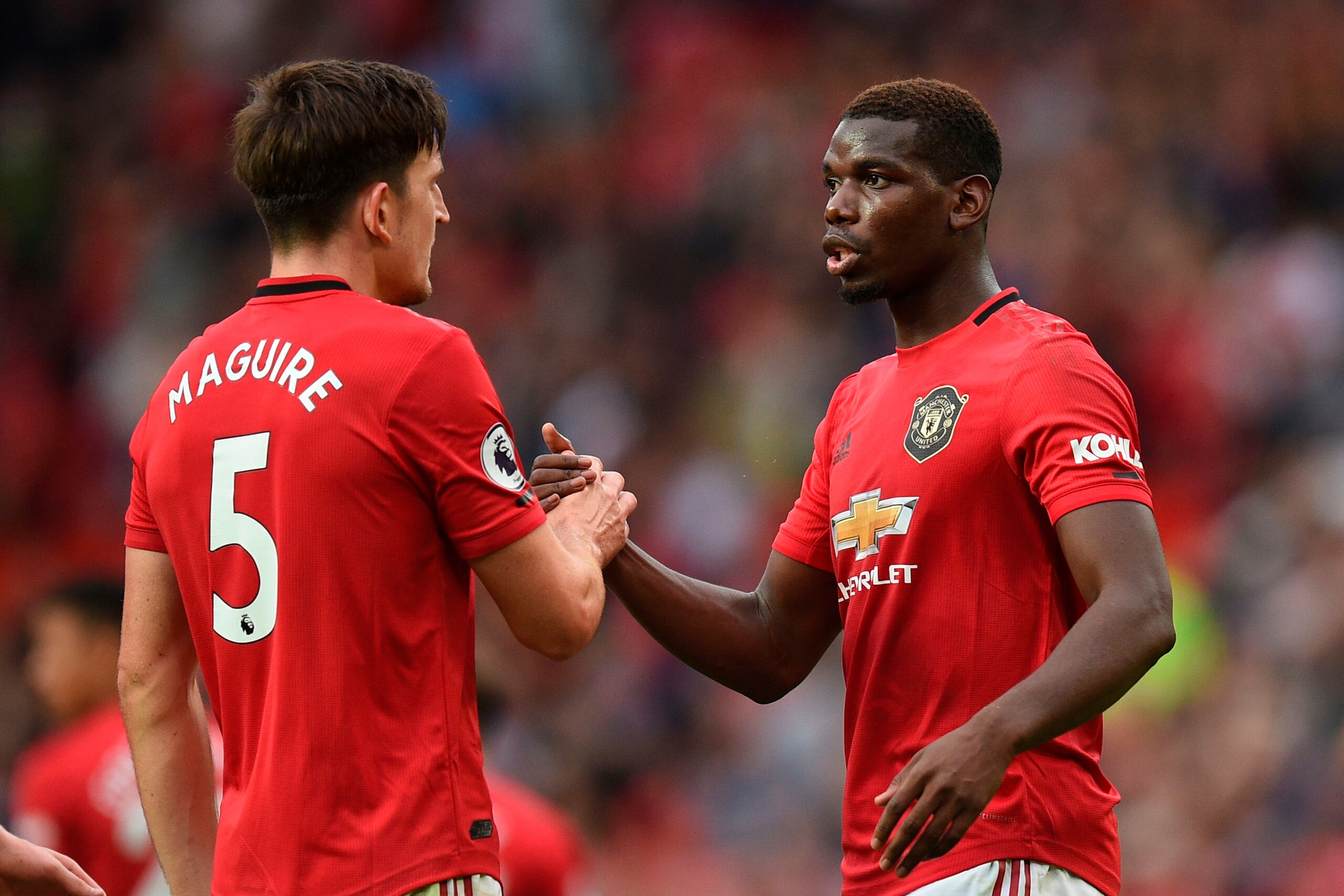Manchester United's English defender Harry Maguire (L) shakes hands with Manchester United's French midfielder Paul Pogba (R) on the pitch at the final whistle in the English Premier League football match between Manchester United and Chelsea at Old Traff