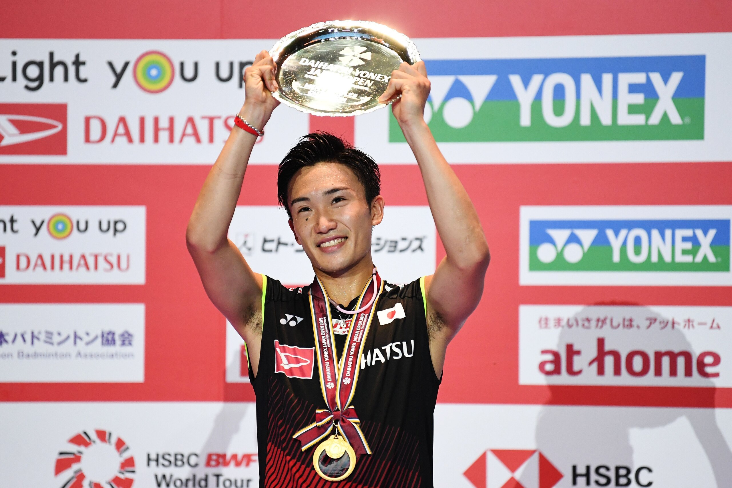 Kento Momota of Japan receive a trophy after the men's singles final match against Jonatan Christie of Indonesia at the Japan Open badminton tournament, a test event ahead of the Tokyo 2020 Olympic Games, in Tokyo on July 28, 2019. (Photo by CHARLY TRIBAL