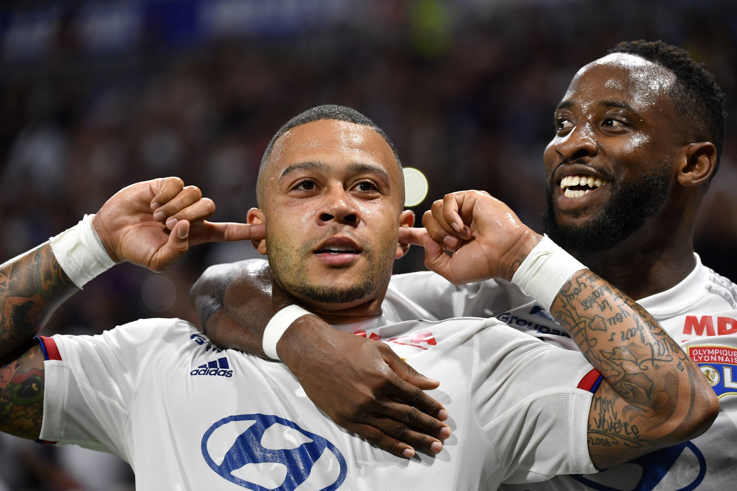 Lyon's Dutch forward Memphis Depay (C) is congratuled by teamate Lyon's French forward Moussa Dembele (R) after scoring a goal celebrates after scoring a goal during the French L1 football match between Olympique Lyonnais (OL) and Angers SCO on August 16,