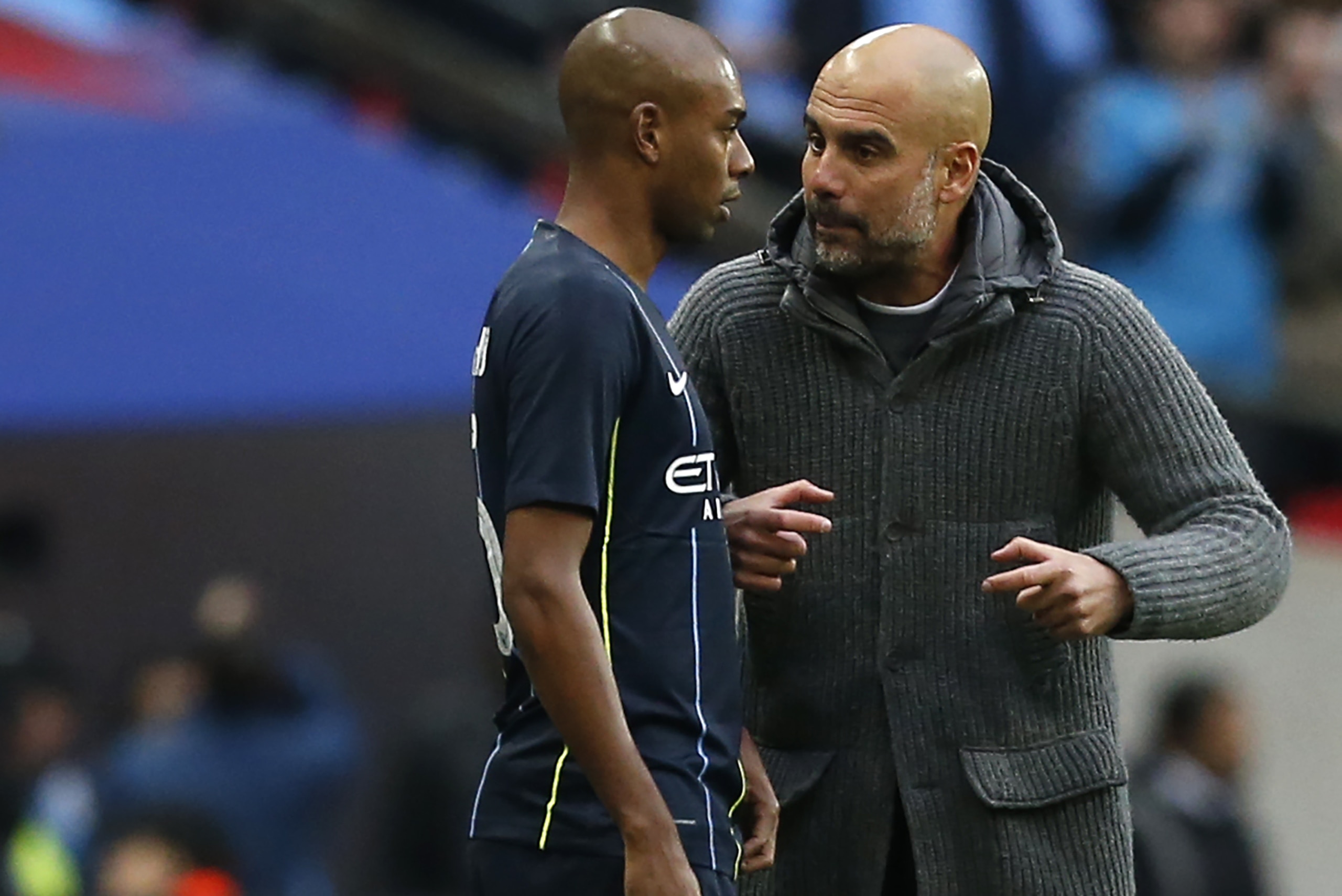 Manchester City's Spanish manager Pep Guardiola (R) preps Manchester City's Brazilian midfielder Fernandinho during the English FA Cup semi-final football match between Manchester City and Brighton and Hove Albion at Wembley Stadium in London, on April 6,