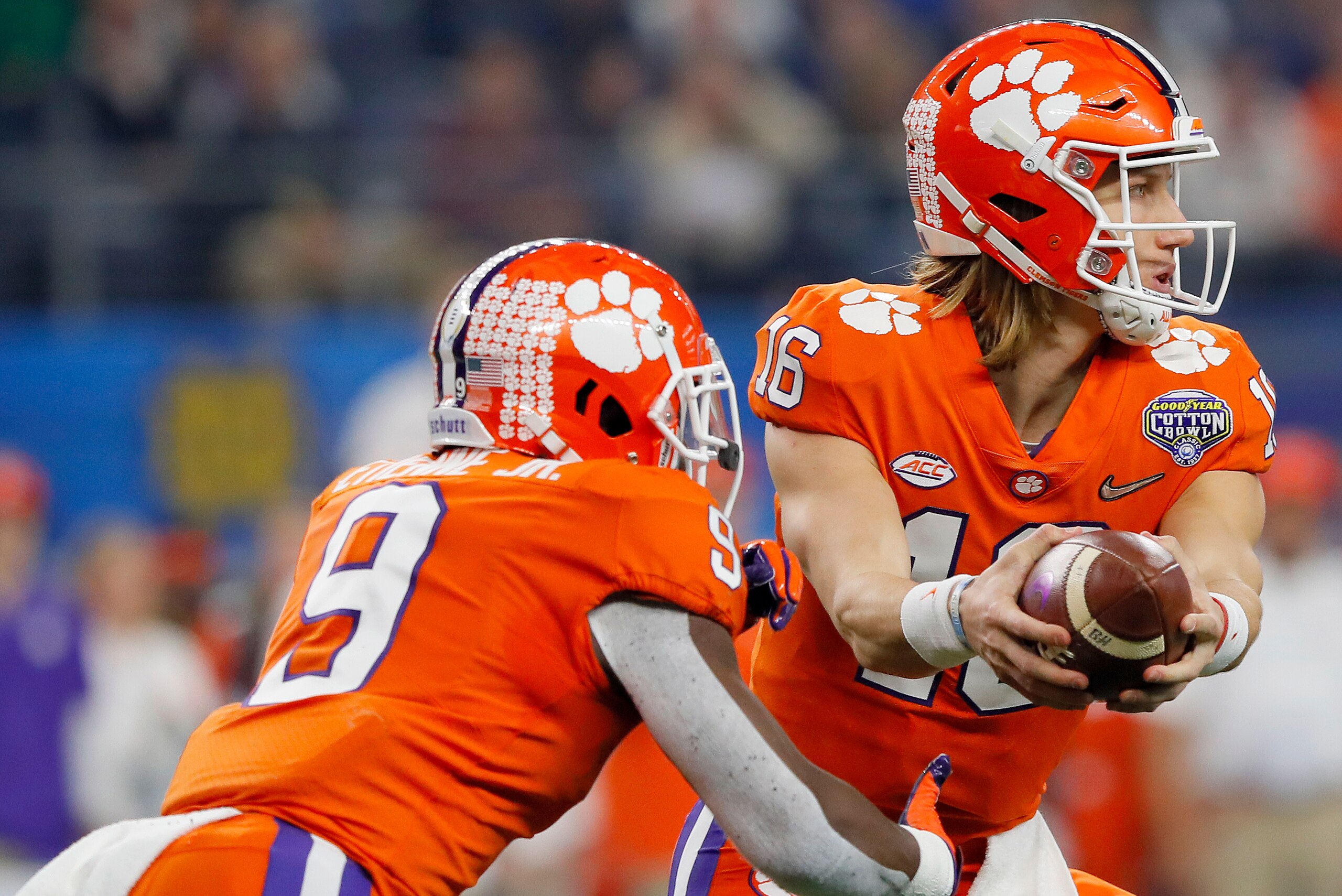 ARLINGTON, TEXAS - DECEMBER 29: Trevor Lawrence #16 of the Clemson Tigers looks to hand off to Travis Etienne #9 in the first half against the Notre Dame Fighting Irish during the College Football Playoff Semifinal Goodyear Cotton Bowl Classic at AT&T Sta