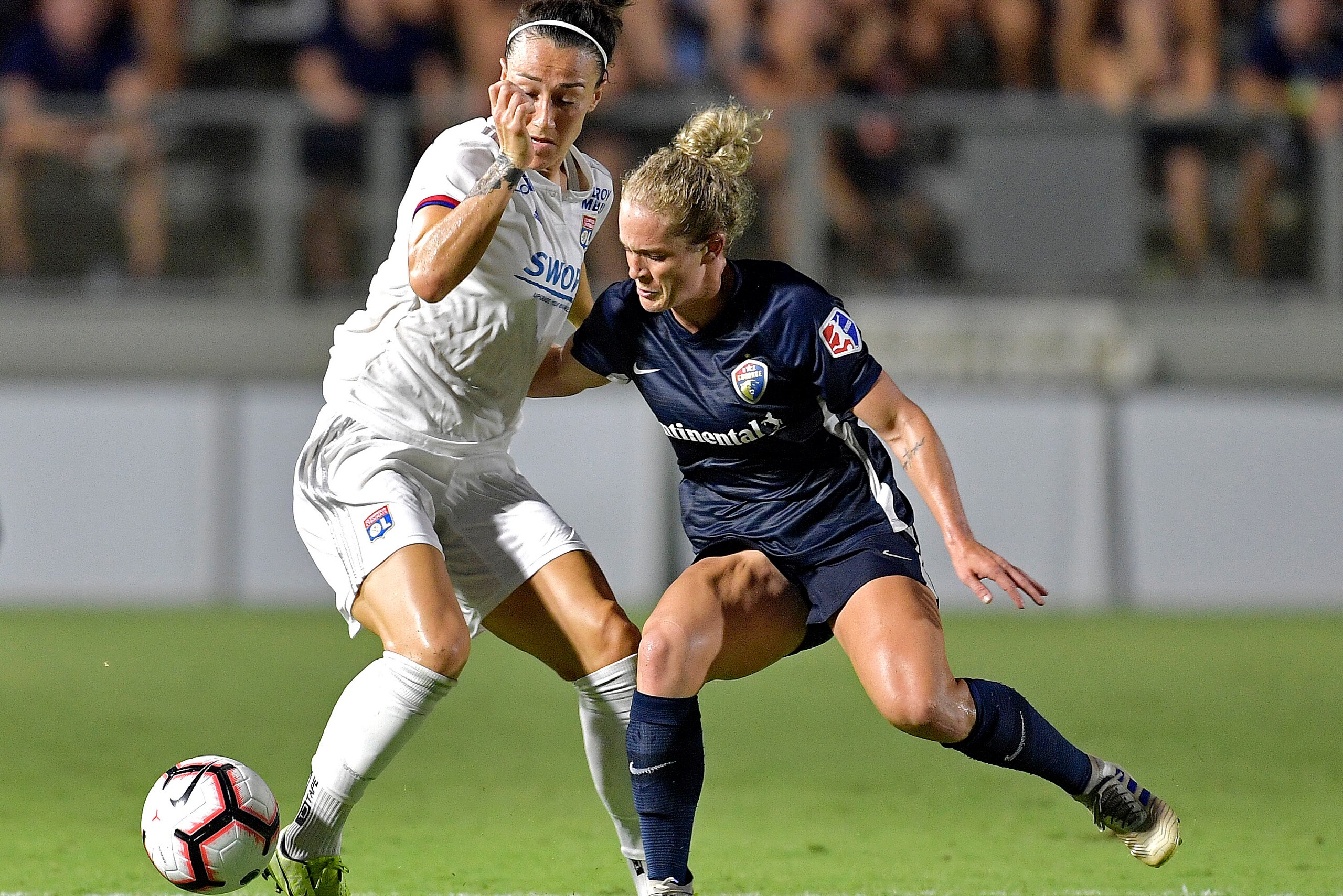 CARY, NORTH CAROLINA - AUGUST 18:  Lucia Bronze #2 of Olympique Lyonnais is defended by Kristen Hamilton #23 of North Carolina Courage during the International Champions Cup championship match at WakeMed Soccer Park on August 18, 2019 in Cary, North Carol