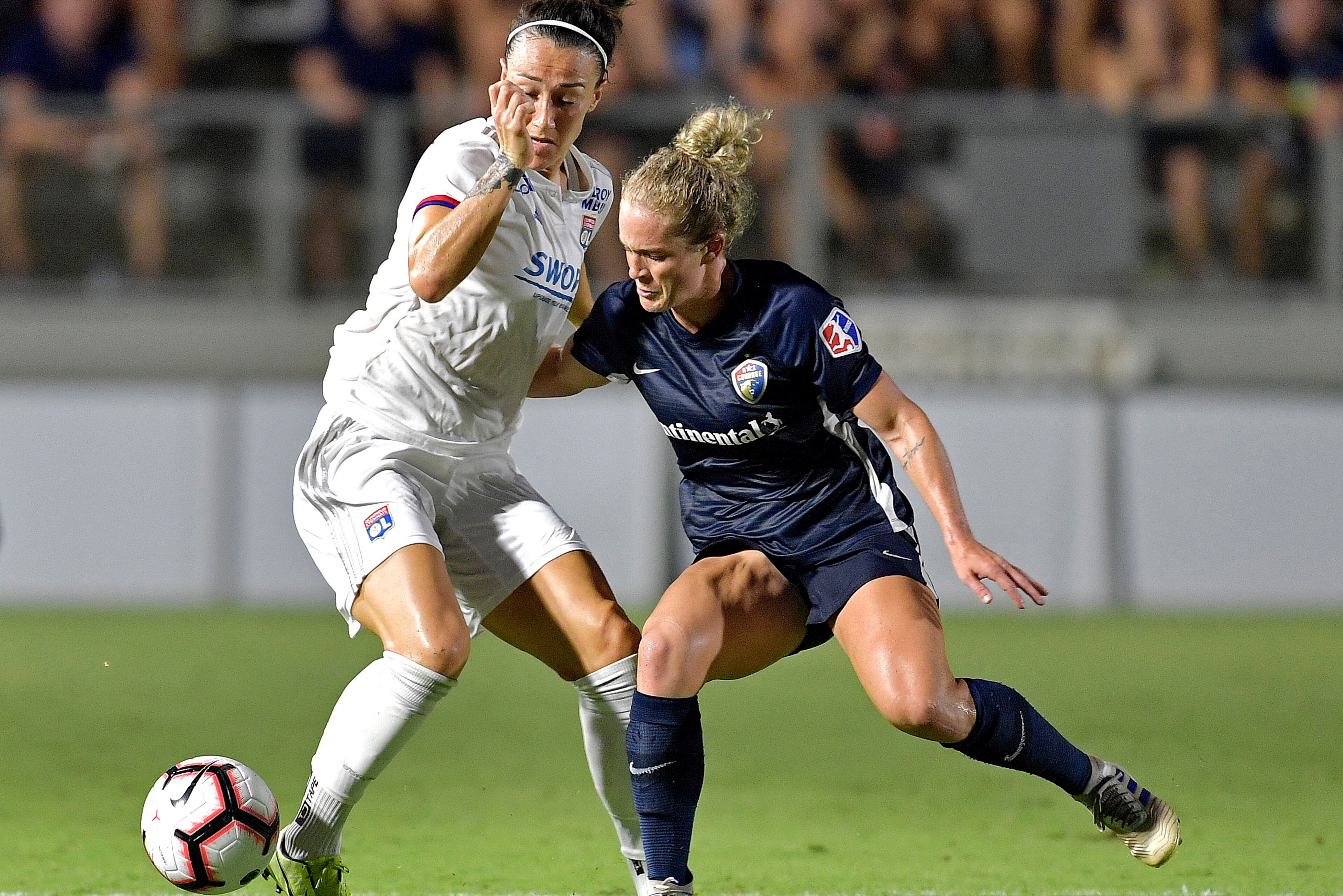 CARY, NORTH CAROLINA - AUGUST 18:  Lucia Bronze #2 of Olympique Lyonnais is defended by Kristen Hamilton #23 of North Carolina Courage during the International Champions Cup championship match at WakeMed Soccer Park on August 18, 2019 in Cary, North Carol