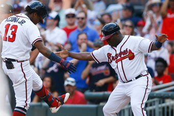 ATLANTA, GEORGIA - JUNE 01: Centerfielder Ronald Acuna, Jr. #13 of the Atlanta Braves celebrates with first base coach Eric Young, Sr. #2 after hitting an RBI single in the fifth inning during the game against the Detroit Tigers at SunTrust Park on June 0