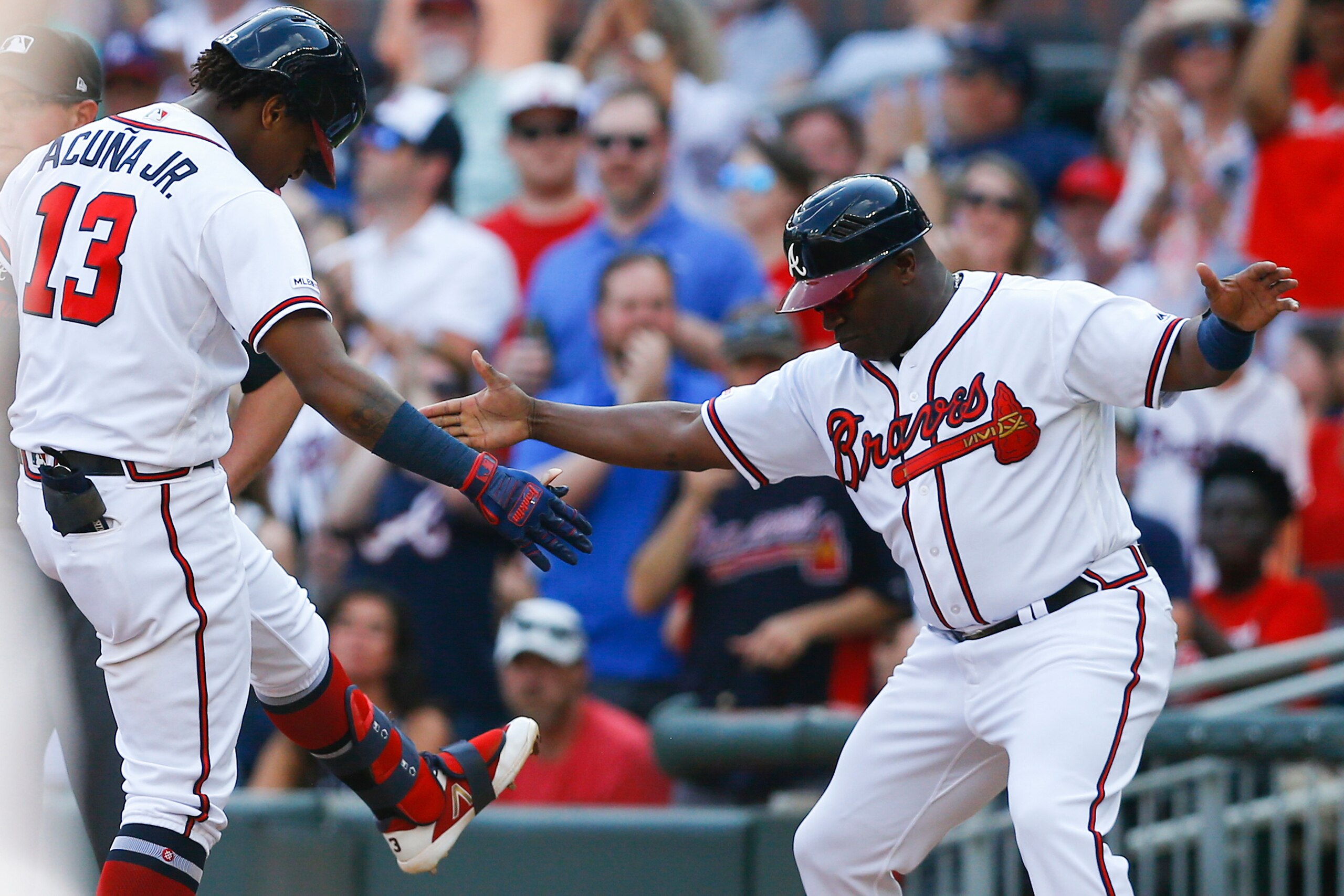 ATLANTA, GEORGIA - JUNE 01: Centerfielder Ronald Acuna, Jr. #13 of the Atlanta Braves celebrates with first base coach Eric Young, Sr. #2 after hitting an RBI single in the fifth inning during the game against the Detroit Tigers at SunTrust Park on June 0 ATLANTA, GEORGIA - JUNE 01: Centerfielder Ronald Acuna, Jr. #13 of the Atlanta Braves celebrates with first base coach Eric Young, Sr. #2 after hitting an RBI single in the fifth inning during the game against the Detroit Tigers at SunTrust Park on June 0