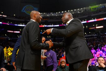 LOS ANGELES, CA - OCTOBER 25:  Former Los Angeles Lakers Kobe Bryant, left and Earvin Magic Johnson, president of basketball operations of the Lakers talk during the game between the Los Angeles Lakers and the Denver Nuggets on October 25, 2018 at STAPLES