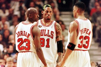 Dennis Rodman of the Chicago Bulls (C) talks to teammates Michael Jordan (L) and Scottie Pippen (L) 10 June during game four of the NBA Finals against the Utah Jazz at the United Center in Chicago, IL. Rodman hit four foul shots down the stretch to lead t