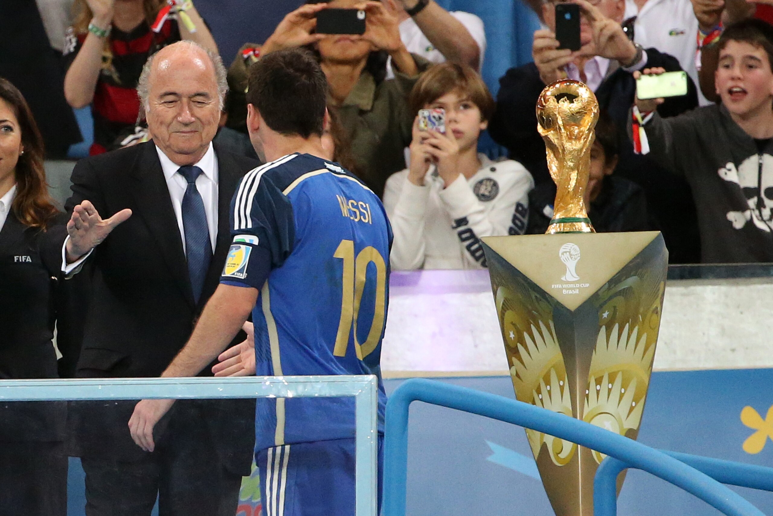 RIO DE JANEIRO, BRAZIL - JULY 13: Lionel Messi of Argentina is passing by the trophy before saluting President of Brazil Dilma Rousseff and FIFA President Joseph Blatter after the 2014 FIFA World Cup Brazil Final match between Germany and Argentina at Est