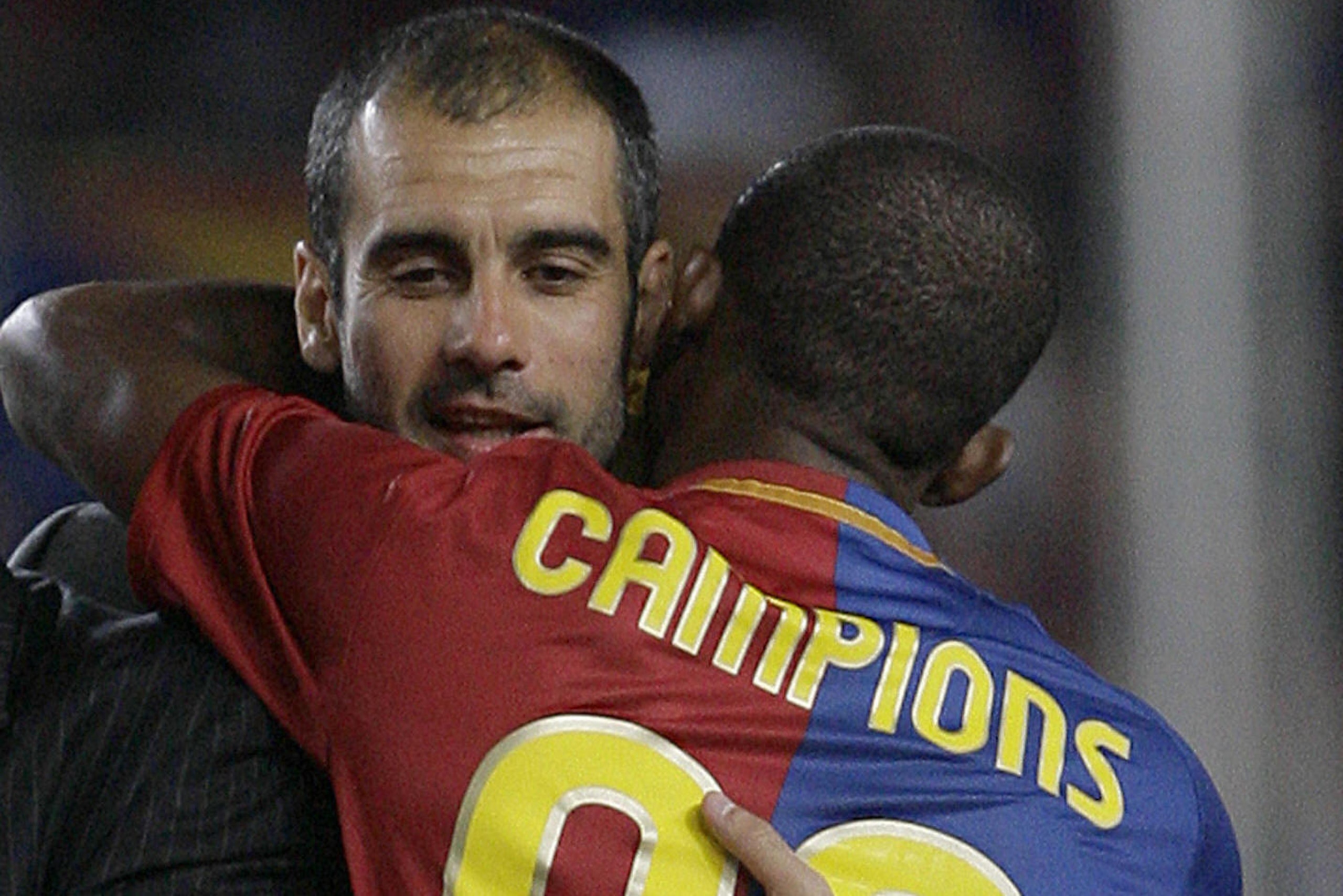 Barcelona's Samuel Eto'o of Cameroon embraces his coach Pep Guardiola following their victory in the Spanish league title 2009 and the Spanish King's cup 2009 after the Liga football match against Osasuna at the Camp Nou Stadium in Barcelona, on May 23, 2
