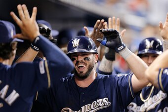 MIAMI, FLORIDA - SEPTEMBER 11:  Mike Moustakas #11 of the Milwaukee Brewers celebrates with teammates after hitting a go-ahead two-run home run in the ninth inning against the Miami Marlins at Marlins Park on September 11, 2019 in Miami, Florida. (Photo b