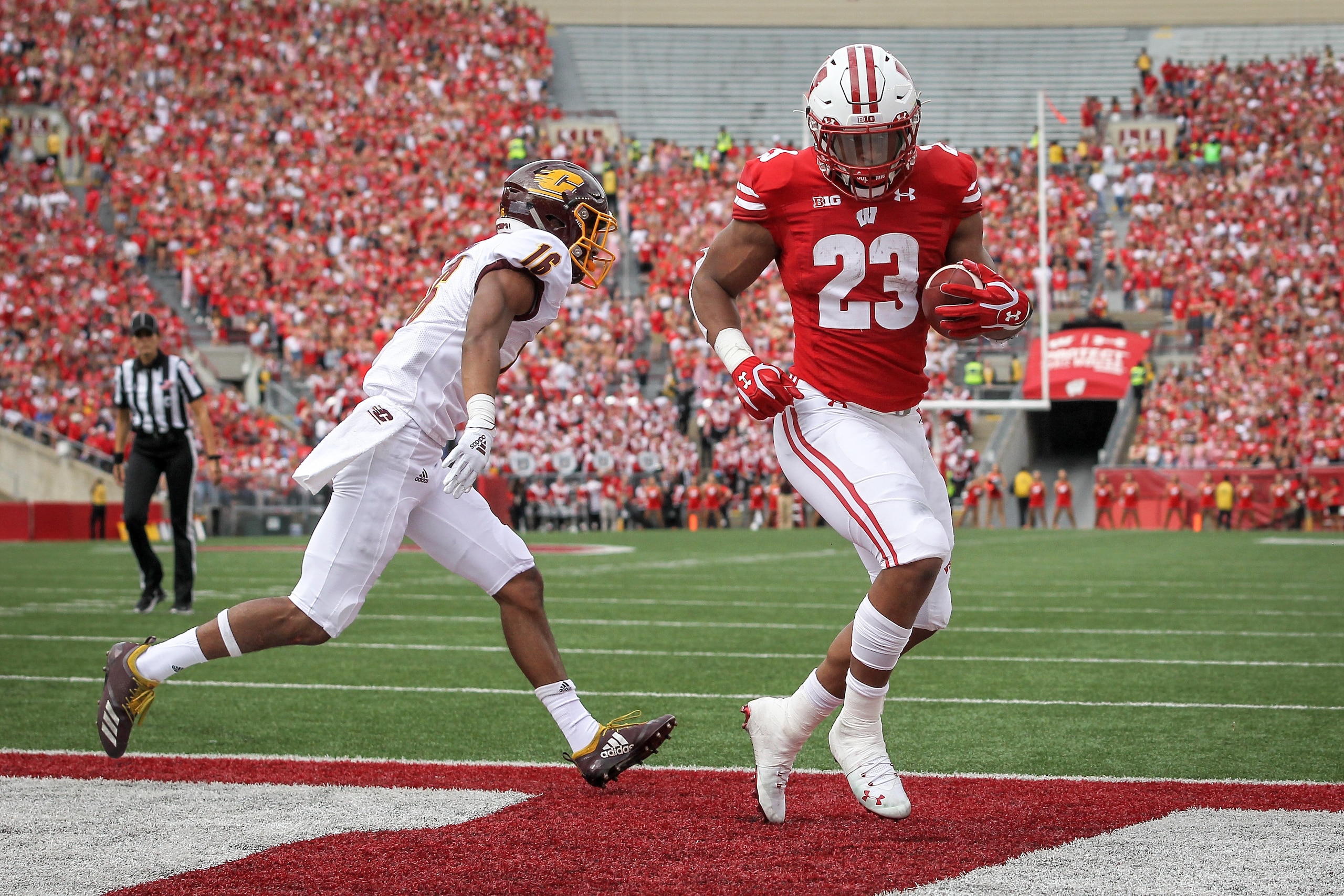 MADISON, WISCONSIN - SEPTEMBER 07:  Jonathan Taylor #23 of the Wisconsin Badgers scores a touchdown past Norman Anderson #16 of the Central Michigan Chippewas in the first quarter at Camp Randall Stadium on September 07, 2019 in Madison, Wisconsin. (Photo