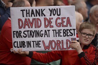 A fan holds up a sign thanking Manchester United's Spanish goalkeeper David de Gea for staying at the club before the English Premier League football match between Manchester United and Liverpool at Old Trafford in Manchester, north west England, on Septe