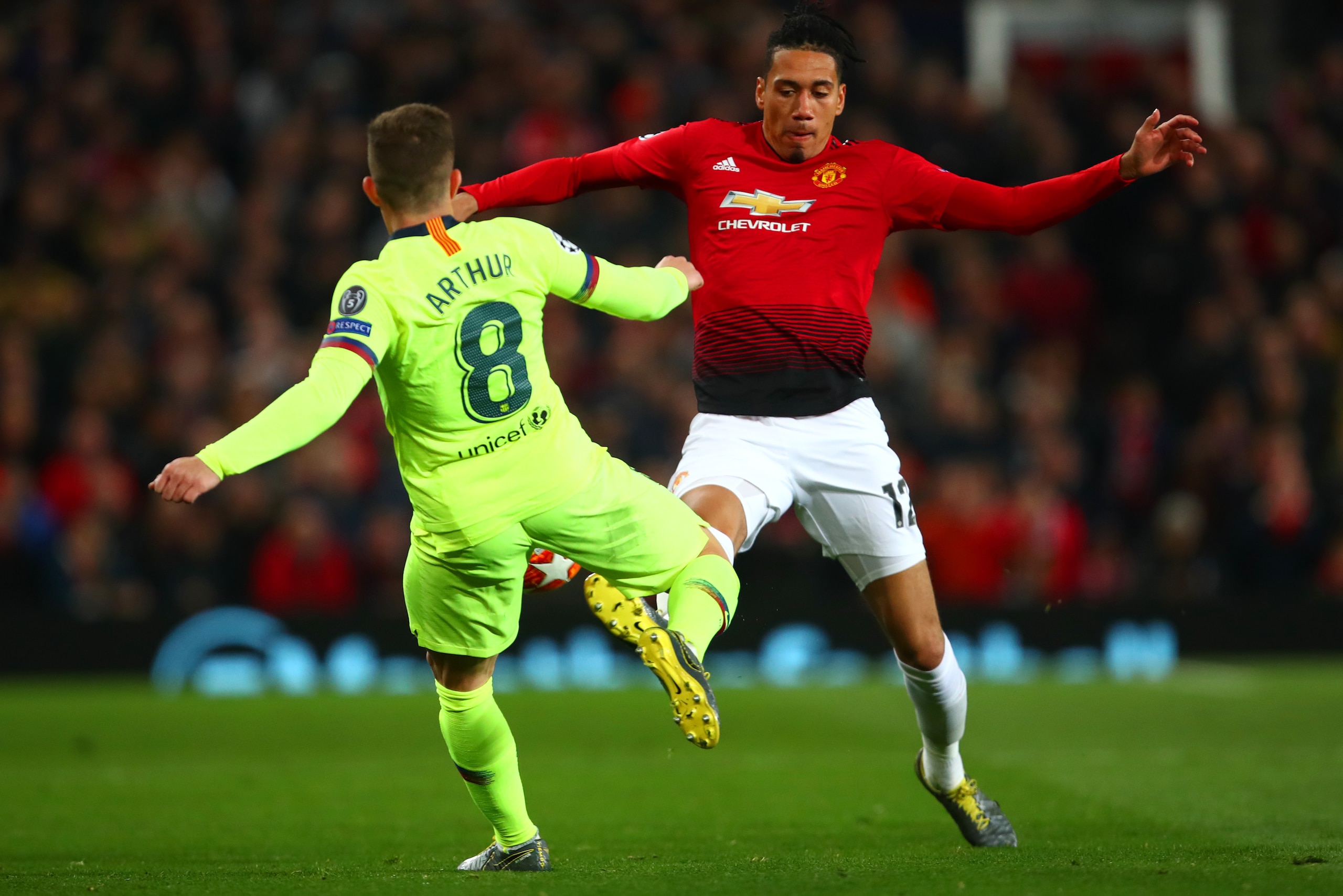 MANCHESTER, ENGLAND - APRIL 10: Chris Smalling of Manchester United competes with Ramos de Oliveira Melo of FC Barcelona during the UEFA Champions League Quarter Final first leg match between Manchester United and FC Barcelona at Old Trafford on April 10 MANCHESTER, ENGLAND - APRIL 10: Chris Smalling of Manchester United competes with Ramos de Oliveira Melo of FC Barcelona during the UEFA Champions League Quarter Final first leg match between Manchester United and FC Barcelona at Old Trafford on April 10