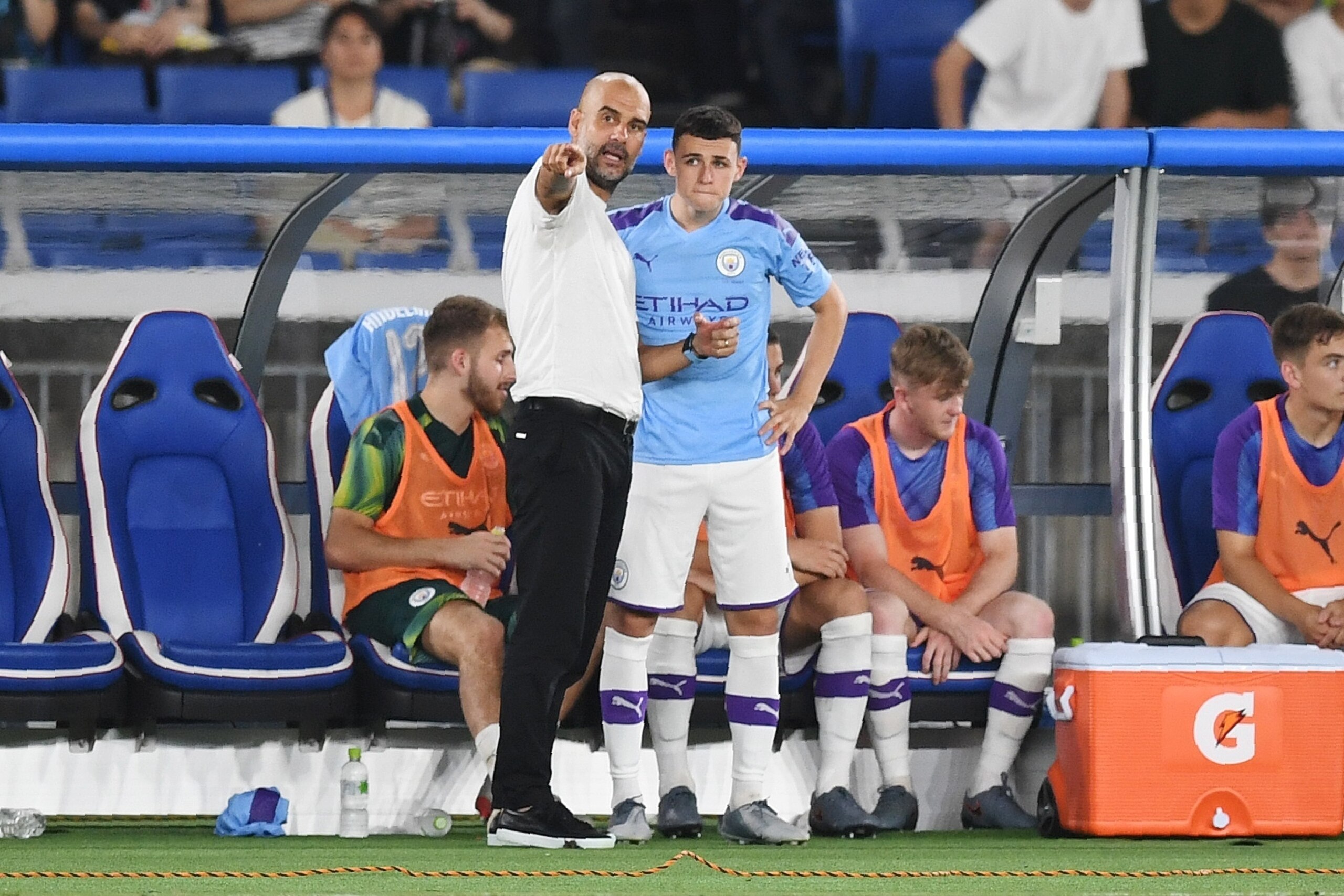 Manchester City's head coach Pep Guardiola talks to Manchester City's midielder Phil Foden during a friendly football match between English Premier League club Manchester City and Japan League Yokohama F. Marinos at the Yokohama Stadium, in Yokohama on Ju