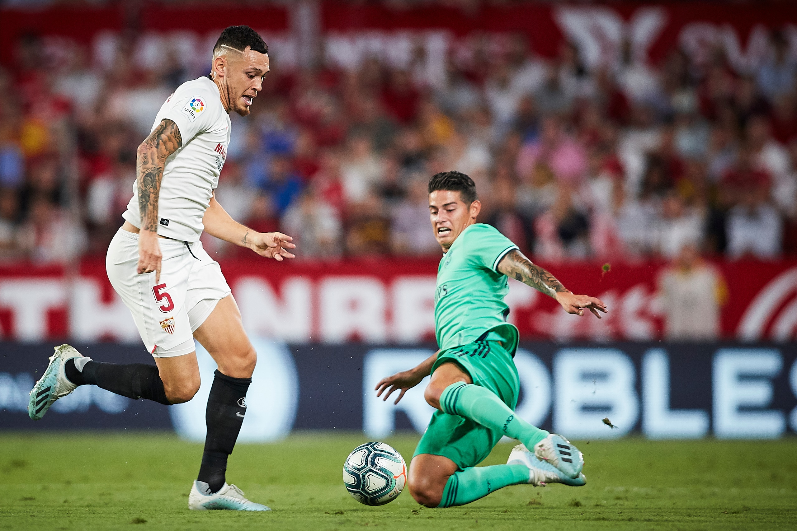 SEVILLE, SPAIN - SEPTEMBER 22: Lucas Ocampos of Sevilla FC competes for the ball with James Rodriguez of Real Madrid during the la Liga match between Sevilla FC and Real Madrid CF at Estadio Ramon Sanchez Pizjuan on September 22, 2019 in Seville, Spain. (
