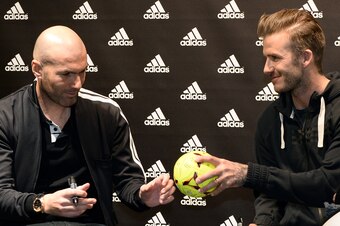 Paris Saint-Germain's (PSG) English midfielder David Beckham (R) and French former international player Zinedine Zidane signs autographs in a store of their sponsor on the Champs-Elysees avenue in Paris, on February 28, 2013. Beckham and Zidane have autog