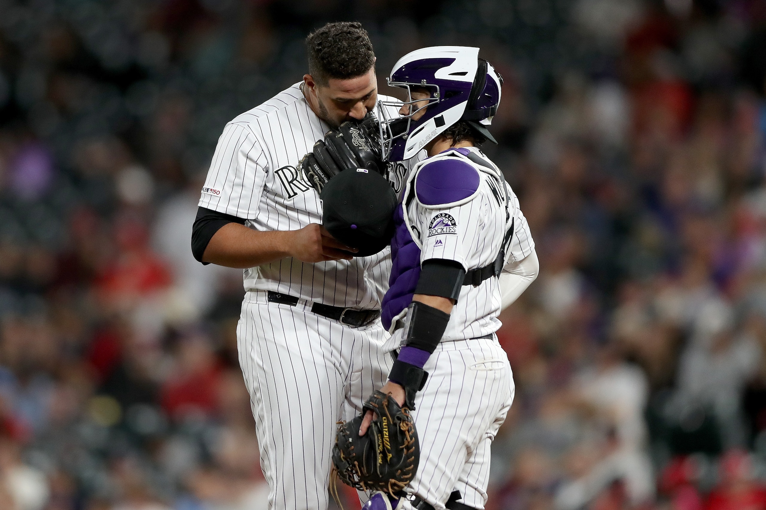 DENVER, COLORADO - SEPTEMBER 11: Pitcher Carlos Estevez #54 and catcher Tony Wolters #14 of the Colorado Rockies confer in the eighth inning against the St Louis Cardinals at Coors Field on September 11, 2019 in Denver, Colorado. (Photo by Matthew Stockma