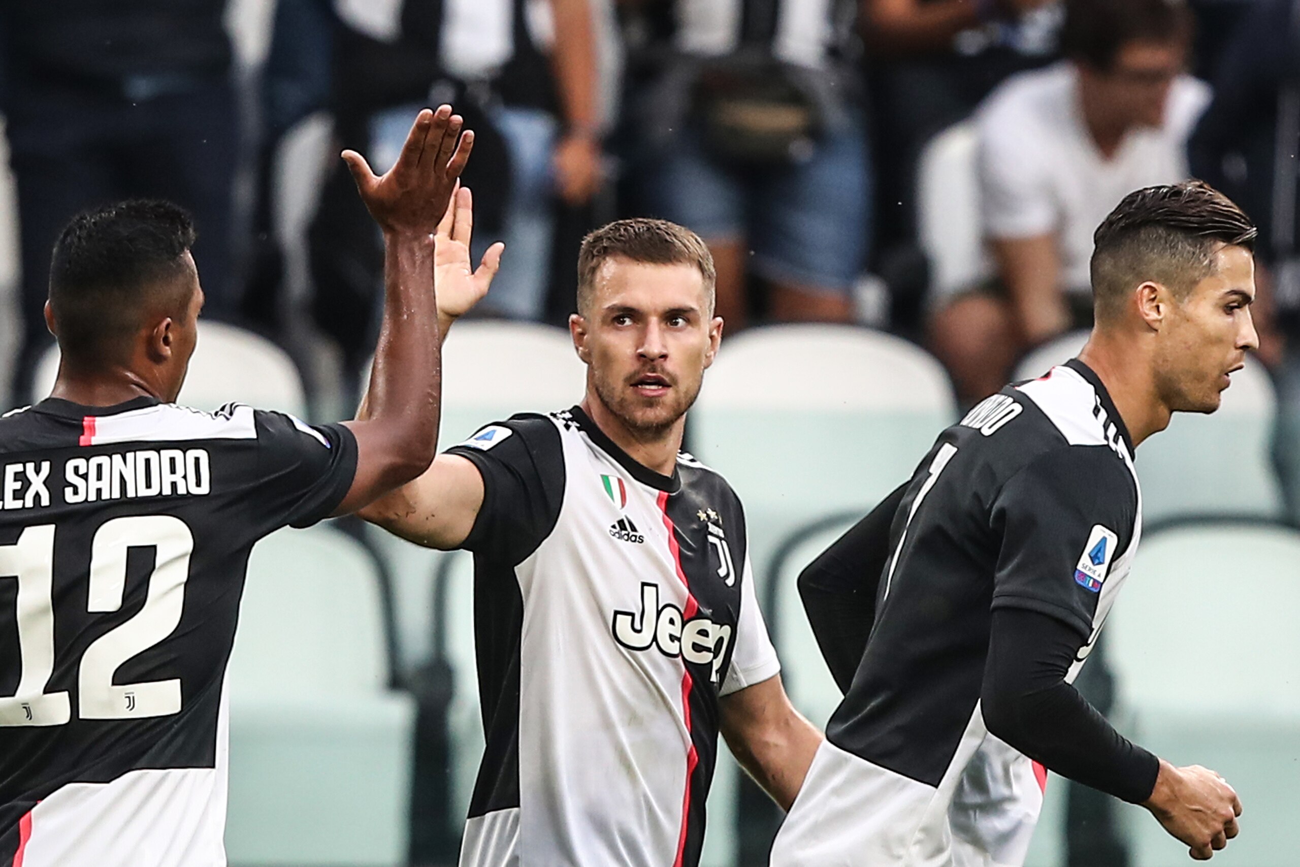 Juventus' Welsh midfielder Aaron Ramsey (C) celebrates after scoring an equalizer with Juventus' Brazilian defender Alex Sandro (L) as Juventus' Portuguese forward Cristiano Ronaldo looks on during the Italian Serie A football match Juventus vs Verona on 