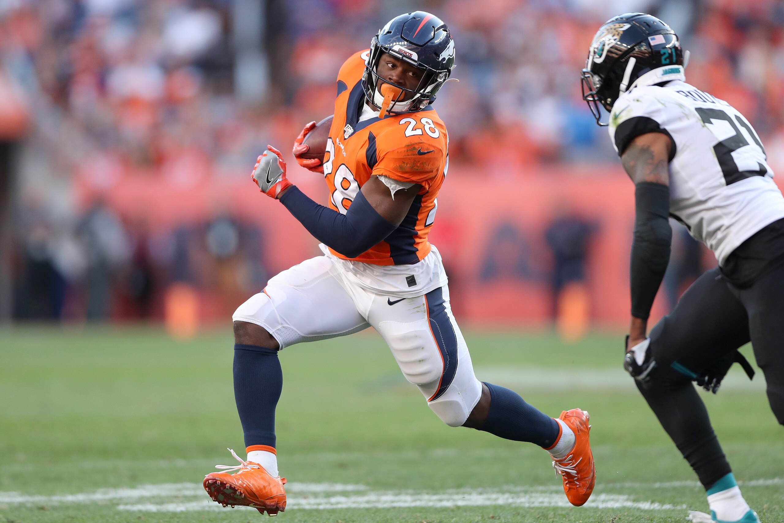 DENVER, COLORADO - SEPTEMBER 29: Royce Freeman #28 of the Denver Broncos carries the ball against A.J. Bouye #21 of the Jacksonville Jaguars in the fourth quarter at Empower Field at Mile High on September 29, 2019 in Denver, Colorado. (Photo by Matthew S